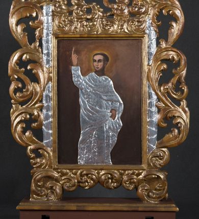 Zdjęcie nr 3: Feretron obrazowy osadzony na prostopadłościennej podstawie z parą otworów na drążki. Pola obrazowe w kształcie stojącego prostokąta ujmuje rzeźbiona, ażurowa rama w formie wici akantu w dolnej partii formującego się w parę dekoracyjnych podpór. W zwieńczeniu, pośród skłębionych akantowych liści znajduje się para zwróconych ku sobie aniołków. Na awersie przedstawiono reprezentacyjny wizerunek św. Józefa w półpostaci. Nieznacznie jest on zwrócony  w trzech czwartych w lewo, natomiast głowę kieruje w prawo. Owalną twarz charakteryzuje miękki modelunek rysów z długim, prostym nosem i krótkim zarostem. Ciemnobrązowe włosy, z puklem nad czołem, są zaczesane do tyłu. Święty po swojej lewej trzyma na rękach Dzieciątko Jezus. Niemal nagą sylwetkę, podobnie jak rysy zaokrąglonej twarzy, charakteryzuje sumaryczny modelunek. Dzieciątko prawą rękę unosi w geście błogosławieństwa, w lewej, wyciągniętej w bok trzyma kwiat białej lilii. Partie szat przesłaniają płaskorzeźbione, złocone i srebrzone sukienki zdobione motywem pojedynczych liści akantu. Głowy okalają świetliste nimby. Tło jest jednolite, ciemnobrązowe. 
Na rewersie feretronu znajduje się wizerunek nierozpoznanego świętego ukazanego niemal w całej postaci. Zwróconego w trzech czwartych w prawo mężczyznę charakteryzuje młodzieńcza fizjonomia owalnej, pozbawionej zarostu twarzy o wyrazistych, sumarycznie opracowanych rysach i mocnym, światłocieniowym modelunku. Włosy przystrzyżone są w formie tonsury. Święty prawą rękę z wyprostowanym palcem wskazującym podnosi wysoko do góry, lewą podtrzymuje połę płaszcza. Sylwetkę osłania płaskorzeźbiona, srebrzona sukienka o układzie naśladującym malarskie drapowanie. Tło obrazu jest jednolite, ciemnobrązowe.     
