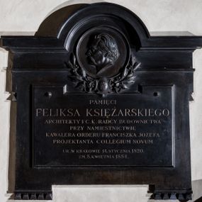 Zdjęcie nr 1: Epitafium w formie prostej tablicy z występami na narożach ozdobionymi łezkowaniem, zwieńczone łukiem półkolistym, nadwieszonym, wewnątrz którego popiersie zmarłego. Mężczyzna jest ukazany z lewego profilu, o włosach zaczesanych do tyłu, z gęstymi, długimi wąsami. Dolną część medalionu ujmują liście lauru spięte tarczą z karbowanymi wstęgami i owalnym, wypukłym polem z cyrklem i trójkątem. Poniżej tablica z dwoma guzami i inskrypcją &quot;PAMIĘCI / FELIKSA KSIĘŻARSKIEGO / ARCHITEKTY I C(ESARSKO) K(RÓLEWSKIEGO) RADCY BUDOWNICTWA / PRZY NAMIESTNICTWIE / KAWALERA ORDERU FRANCISZKA JÓZEFA / PROJEKTANTA COLLEGIUM NOVUM / UR(ODZONEGO) W KRAKOWIE 14. STYCZNIA 1820. / ZM(ARŁEGO) 8. KWIETNIA 1884&quot;. W prawym dolnym rogu sygnatura &quot;W(ładysław) Chrośnikiewicz&quot;. Druga sygnatura na szyi w popiersiu &quot;MOD(ELOWAŁ) Przebindowski / ODL(EWAŁ) Kopaczyński / Kraków&quot;. 
