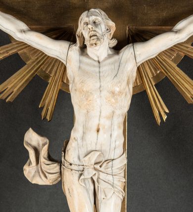 Zdjęcie nr 1: Rzeźba pełna, złożona z trzech ciosów – korpusu i dwóch rąk. Chrystus w typie Cristo vivo, przybity do krzyża trzema gwoździami jest ukazany w lekkim zwisie, z nieznacznie przegiętym ciałem i z szeroko rozłożonymi rękami. Jego głowa jest lekko odchylona do tyłu i nieznacznie przegięta w prawo, wzrok wznosi ku górze, usta szeroko otwarte z widocznym uzębieniem, wokół brody krótki zarost, a na głowie układające się faliście włosy, sięgające ramion. Anatomia ciała oddana poprawnie, z wypiętą klatką piersiową i umięśnionymi smukłymi nogami z krzyżującymi się stopami; na biodrach perizonium podwieszone na podwójnym, skręconym sznurze, z odsłoniętym prawym biodrem i swobodnie powiewającą z prawej strony połą materii. Krzyż o ramionach zakończonych trójlistnie, z glorią promienistą na skrzyżowaniu belek. Na górnej belce titulus z literami „IN/RI”. 
