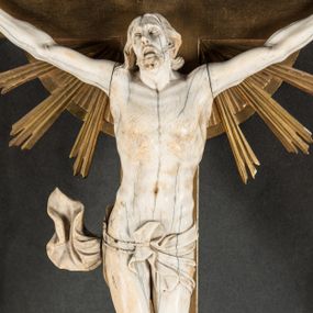 Zdjęcie nr 1: Rzeźba pełna, złożona z trzech ciosów – korpusu i dwóch rąk. Chrystus w typie Cristo vivo, przybity do krzyża trzema gwoździami jest ukazany w lekkim zwisie, z nieznacznie przegiętym ciałem i z szeroko rozłożonymi rękami. Jego głowa jest lekko odchylona do tyłu i nieznacznie przegięta w prawo, wzrok wznosi ku górze, usta szeroko otwarte z widocznym uzębieniem, wokół brody krótki zarost, a na głowie układające się faliście włosy, sięgające ramion. Anatomia ciała oddana poprawnie, z wypiętą klatką piersiową i umięśnionymi smukłymi nogami z krzyżującymi się stopami; na biodrach perizonium podwieszone na podwójnym, skręconym sznurze, z odsłoniętym prawym biodrem i swobodnie powiewającą z prawej strony połą materii. Krzyż o ramionach zakończonych trójlistnie, z glorią promienistą na skrzyżowaniu belek. Na górnej belce titulus z literami „IN/RI”. 
