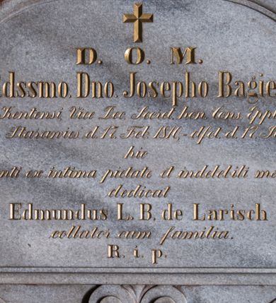 Zdjęcie nr 1: Tablica kamienna w kształcie leżącego prostokąta o narożach ujętych uszakami, zamknięta łukiem eliptycznym. Całość ujęta wąskim, profilowanym obramowaniem. U dołu zdobiona podwieszeniem w formie pary stykających się wolut z motywem palmety pomiędzy nimi. Pole płyciny wypełnia wykuty i złocony napis „D(eo) O(ptimo) M(aximo) / R(everen)d(i)ss(i)mo. D(omi)no. Josepho Bagier / Curato Kentensi, Vice Dec(ano) Secret(ario) hon(orarius) Cons(istori) Ep(isco)p(a)lis Tarn(oviensis) / nat(us) in Starawieś d(ie) 17. Feb(ruarii) 1810, - d(e)f(un)ct(us) d(ie) 17. Jul(ii), 1881. / hic / quiescenti ex intima pietate et indelebili memoria / dedicat / Edmundus L(iber) B(aro) de Larisch / collator cum familia. / R(equiescat) i(n) p(ace)”.