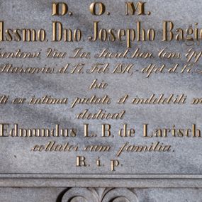 Zdjęcie nr 1: Tablica kamienna w kształcie leżącego prostokąta o narożach ujętych uszakami, zamknięta łukiem eliptycznym. Całość ujęta wąskim, profilowanym obramowaniem. U dołu zdobiona podwieszeniem w formie pary stykających się wolut z motywem palmety pomiędzy nimi. Pole płyciny wypełnia wykuty i złocony napis „D(eo) O(ptimo) M(aximo) / R(everen)d(i)ss(i)mo. D(omi)no. Josepho Bagier / Curato Kentensi, Vice Dec(ano) Secret(ario) hon(orarius) Cons(istori) Ep(isco)p(a)lis Tarn(oviensis) / nat(us) in Starawieś d(ie) 17. Feb(ruarii) 1810, - d(e)f(un)ct(us) d(ie) 17. Jul(ii), 1881. / hic / quiescenti ex intima pietate et indelebili memoria / dedicat / Edmundus L(iber) B(aro) de Larisch / collator cum familia. / R(equiescat) i(n) p(ace)”.