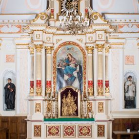 Zdjęcie nr 1: Ołtarz architektoniczny, jednokondygnacyjny, jednoosiowy, ze zwieńczeniem. Prostopadłościenny ołtarz, z antepedium artykułowanym 3 płycinami o dekoracyjnym wykroju, wtopiony jest z dolną partią, zryzalitowanego cokołu retabulum, której układ powtarza także górna partia cokołu. Część środkowa ujęta jest trzema parami kolumn korynckich, z których środkowe są wysunięte i ustawione na tle filarów. Podpory wspierają wyłamujące się ponad nimi, przerwane w partii architrawu i fryzu belkowanie. Druga kondygnacja jest w formie stojącego prostokąta ujętego parą ustawionych na cokołach kolumienek wspierających przerwane, wyłamujące się ponad nimi belkowanie. Dodatkowo ujmuje ją para spływów wolutowych oraz przerwany, wolutowy przyczółek. Zwieńczenie zamknięte jest parą stykających się wolut oraz ujęte przerwanym przyczółkiem wolutowym. Szczyt jest w formie ażurowej ornamentyki akantowo-rocaille’owej. W polu środkowym retabulum jest obraz w kształcie stojącego prostokąta zamkniętego półkoliście z przedstawieniem Matki Boskiej Różańcowej ze św. Dominikiem i św. Małgorzatą Alacoque. W polu zwieńczenia profilowana rama w kształcie prostokąta z uszakami w narożach, zamkniętego łukiem odcinkowym, z ażurowym monogramem maryjnym pośrodku, ujętym wieńcem obłoków i promienistą glorią. Retabulum zdobi stylizowana ornamentyka roślinna w postaci liści akantu i  dziewięćsiłu w formie rozet w płycinach antepedium i górnej partii cokołu retabulum oraz we fryzie. Nasada trzonów kolumn ujęta liśćmi akantu i gałązkami róż. Gzyms belkowania zdobi motyw astragalu. Struktura ołtarza utrzymana jest odcieniu kremowym, detal architektoniczny i ornamentyka częściowo są polichromowane w kolorze czerwonym oraz złocone.  