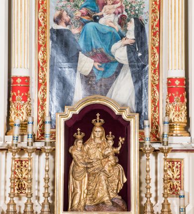 Zdjęcie nr 3: Ołtarz architektoniczny, jednokondygnacyjny, jednoosiowy, ze zwieńczeniem. Prostopadłościenny ołtarz, z antepedium artykułowanym 3 płycinami o dekoracyjnym wykroju, wtopiony jest z dolną partią, zryzalitowanego cokołu retabulum, której układ powtarza także górna partia cokołu. Część środkowa ujęta jest trzema parami kolumn korynckich, z których środkowe są wysunięte i ustawione na tle filarów. Podpory wspierają wyłamujące się ponad nimi, przerwane w partii architrawu i fryzu belkowanie. Druga kondygnacja jest w formie stojącego prostokąta ujętego parą ustawionych na cokołach kolumienek wspierających przerwane, wyłamujące się ponad nimi belkowanie. Dodatkowo ujmuje ją para spływów wolutowych oraz przerwany, wolutowy przyczółek. Zwieńczenie zamknięte jest parą stykających się wolut oraz ujęte przerwanym przyczółkiem wolutowym. Szczyt jest w formie ażurowej ornamentyki akantowo-rocaille’owej. W polu środkowym retabulum jest obraz w kształcie stojącego prostokąta zamkniętego półkoliście z przedstawieniem Matki Boskiej Różańcowej ze św. Dominikiem i św. Małgorzatą Alacoque. W polu zwieńczenia profilowana rama w kształcie prostokąta z uszakami w narożach, zamkniętego łukiem odcinkowym, z ażurowym monogramem maryjnym pośrodku, ujętym wieńcem obłoków i promienistą glorią. Retabulum zdobi stylizowana ornamentyka roślinna w postaci liści akantu i  dziewięćsiłu w formie rozet w płycinach antepedium i górnej partii cokołu retabulum oraz we fryzie. Nasada trzonów kolumn ujęta liśćmi akantu i gałązkami róż. Gzyms belkowania zdobi motyw astragalu. Struktura ołtarza utrzymana jest odcieniu kremowym, detal architektoniczny i ornamentyka częściowo są polichromowane w kolorze czerwonym oraz złocone.  