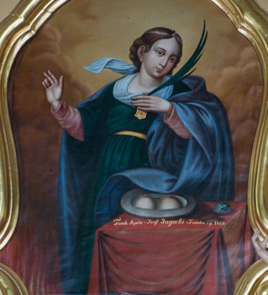 Zdjęcie nr 1: Obraz uzyskał kształt pionowego prostokąta wklęsło-wypukłymi bokami ujętymi w złoconą, profilowana ramę. W centrum kompozycji ukazano stojącą za stołem frontalnie św. Agatę. Męczenniczka z głową ujętą w trzech czwartych w prawo nieznacznie jest odchylona w prawo. Prawą rękę w geście mowy unosi na wysokość piersi, do których przyciska lewą rękę z gałązką palmową. Święta ma owalną twarz o jasnej karnacji z rumianymi policzkami, wydatnym nosem i ustami oraz spojrzeniem ciemnych oczu skierowanym na widza. Jej głowę okalają brązowe, falujące włosy spływające na plecy. Na głowie widoczna jest tasiemka z klejnotem nad czołem. Ubrana jest w ciemnozieloną suknię spiętą w pasie złotym paskiem widoczną spod niej w partii rękawów różową koszulę oraz w narzucony na ramiona błękitny płaszcz przerzucony przez lewe przedramię. Na pierwszym planie w prawym rogu kompozycji czworoboczny stolik nakryty szkarłatną tkaniną. Na nim leży srebrzysty półmisek z dwiema odciętymi piersiami, a obok chleb i niebiesko-biały kamień. W lewym rogu kompozycji widoczne są płomienie. W tle widoczne są obłoki w odcieniach żółci i brązu. Na krawędzi stołu umieszczono napis: "Fund[ndowali] Agata i Józef Jagocki z Familią r[oku] p[ańskiego] 1866". 