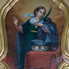 Zdjęcie nr 1: Obraz uzyskał kształt pionowego prostokąta wklęsło-wypukłymi bokami ujętymi w złoconą, profilowana ramę. W centrum kompozycji ukazano stojącą za stołem frontalnie św. Agatę. Męczenniczka z głową ujętą w trzech czwartych w prawo nieznacznie jest odchylona w prawo. Prawą rękę w geście mowy unosi na wysokość piersi, do których przyciska lewą rękę z gałązką palmową. Święta ma owalną twarz o jasnej karnacji z rumianymi policzkami, wydatnym nosem i ustami oraz spojrzeniem ciemnych oczu skierowanym na widza. Jej głowę okalają brązowe, falujące włosy spływające na plecy. Na głowie widoczna jest tasiemka z klejnotem nad czołem. Ubrana jest w ciemnozieloną suknię spiętą w pasie złotym paskiem widoczną spod niej w partii rękawów różową koszulę oraz w narzucony na ramiona błękitny płaszcz przerzucony przez lewe przedramię. Na pierwszym planie w prawym rogu kompozycji czworoboczny stolik nakryty szkarłatną tkaniną. Na nim leży srebrzysty półmisek z dwiema odciętymi piersiami, a obok chleb i niebiesko-biały kamień. W lewym rogu kompozycji widoczne są płomienie. W tle widoczne są obłoki w odcieniach żółci i brązu. Na krawędzi stołu umieszczono napis: "Fund[ndowali] Agata i Józef Jagocki z Familią r[oku] p[ańskiego] 1866". 