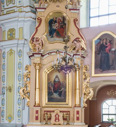 Zdjęcie nr 1: Przyścienny ołtarz drewniany, jednoosiowy ze zwieńczeniem otrzymał formę architektoniczną. Nastawa wspiera się na nowym, prostopadłościennym stipesie marmurowym z mensą, artykułowany od przodu dwiema smukłymi półkolumienkami, pomiędzy którymi umieszczono metalową i złoconą aplikację z przedstawieniem Najświętszego Serca Pana Jezusa. Na mensie ustawiono tabernakulum w formie prostopadłościennej skrzynki o wklęsło-wypukłych bokach, ustawione na czterech profilowanych nóżkach. Drzwiczki ozdobiono płaskorzeźbionym kielichem z hostią ujętym wklęsło wypukłym obramieniem. Jednokondygnacyjną nastawę ustawiono na dwustrefowym cokole. Partia cokołu ozdobiona została płycinami w kształcie pionowych prostokątów, a w osi środkowej w kształcie kwadratów. Płyciny wypełniono rzeźbioną dekoracją floralną na czerwonym tle. Kondygnacja retabulum ujęta została parą złoconych kolumn, podtrzymujących wyłamane nad polem środkowym belkowanie. Kolumny o kompozytowych kapitelach ustawiono na profilowanych bazach, w jednej trzeciej wysokości przedzielone zostały opaską, zaś w części dolnej ozdobiono je żłobkowaniem. Na belkowaniu umieszczono parę uskrzydlonych aniołków. Pole środkowe ujęte zostało w prostokątną, profilowaną ramę, zamkniętą od góry łukiem wklęsło-wypukłym z uskokami. W niej prezentowany jest obraz Jezusa Bielańskiego w typie Ecce Homo, a na zasuwie obraz Najświętszego Serca Pana Jezusa. Po bokach nastawy umieszczono ażurowe, złocone wici akantowe pełniące role uszaków. Zwieńczenie uzyskało formę prostokąta stojącego ujętego po bokach dwiema lizenami i spływami wolutowymi. Wieńczy je przerywane belkowanie, na którym usytuowano parę siedzących aniołków. W polu zwieńczenia umieszczono obraz Świętej Rodziny we wklęsło-wypukłej ramie. Natomiast szczyt zwieńczenia ozdobiono złoconym chrystogramem "IHS" na czerwonym tle, otoczonym wieńcem z obłoków i promienistą glorią. Strukturę nastawy pomalowano w kolorze beżowym, a ornamentykę wyzłocono i wysrebrzono.