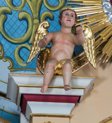 Zdjęcie nr 3: Przyścienny ołtarz drewniany, jednoosiowy ze zwieńczeniem otrzymał formę architektoniczną. Nastawa wspiera się na nowym, prostopadłościennym stipesie marmurowym z mensą, artykułowany od przodu dwiema smukłymi półkolumienkami, pomiędzy którymi umieszczono metalową i złoconą aplikację z przedstawieniem Najświętszego Serca Pana Jezusa. Na mensie ustawiono tabernakulum w formie prostopadłościennej skrzynki o wklęsło-wypukłych bokach, ustawione na czterech profilowanych nóżkach. Drzwiczki ozdobiono płaskorzeźbionym kielichem z hostią ujętym wklęsło wypukłym obramieniem. Jednokondygnacyjną nastawę ustawiono na dwustrefowym cokole. Partia cokołu ozdobiona została płycinami w kształcie pionowych prostokątów, a w osi środkowej w kształcie kwadratów. Płyciny wypełniono rzeźbioną dekoracją floralną na czerwonym tle. Kondygnacja retabulum ujęta została parą złoconych kolumn, podtrzymujących wyłamane nad polem środkowym belkowanie. Kolumny o kompozytowych kapitelach ustawiono na profilowanych bazach, w jednej trzeciej wysokości przedzielone zostały opaską, zaś w części dolnej ozdobiono je żłobkowaniem. Na belkowaniu umieszczono parę uskrzydlonych aniołków. Pole środkowe ujęte zostało w prostokątną, profilowaną ramę, zamkniętą od góry łukiem wklęsło-wypukłym z uskokami. W niej prezentowany jest obraz Jezusa Bielańskiego w typie Ecce Homo, a na zasuwie obraz Najświętszego Serca Pana Jezusa. Po bokach nastawy umieszczono ażurowe, złocone wici akantowe pełniące role uszaków. Zwieńczenie uzyskało formę prostokąta stojącego ujętego po bokach dwiema lizenami i spływami wolutowymi. Wieńczy je przerywane belkowanie, na którym usytuowano parę siedzących aniołków. W polu zwieńczenia umieszczono obraz Świętej Rodziny we wklęsło-wypukłej ramie. Natomiast szczyt zwieńczenia ozdobiono złoconym chrystogramem "IHS" na czerwonym tle, otoczonym wieńcem z obłoków i promienistą glorią. Strukturę nastawy pomalowano w kolorze beżowym, a ornamentykę wyzłocono i wysrebrzono.