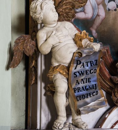 Zdjęcie nr 10: Ołtarz architektoniczny, jednokondygnacyjny, jednoosiowy, ze zwieńczeniem. Ołtarz prostopadłościenny, murowany. Retabulum o strukturze wklęsłej wzdłuż osi pionowej osadzone na niewysokim, cokole zryzalitowanym w formie pary impostów. Gzyms cokołu pośrodku ma formę półkolistego łuku nadwieszonego. Część środkowa ujęta parą wąskich filarów, licami zwróconych ukośnie na zewnątrz, wspierających wydatny gzyms osadzony na parze spływów wolutowych. Pola cokołu retabulum zdobione ornamentyką roślinną. Na impostach para figur aniołków, stojący po lewej stronie w lewej dłoni ma zwój z napisem „PATRZ / SWEGO / A NIE / PRAGNIJ / CUDZEGO”, stojący po prawej trzyma lewą ręką wspartą na podłożu tarczę z napisem „ZLE / NABYTE / NIE / BĘDZIE / DOBRZE / SPOŻYTE”. Między impostami płycina w kształcie prostokąta leżącego o wklęsłych górnych narożach i zamkniętego półkolistym łukiem nadwieszonym. W dolnej partii retabulum para uskrzydlonych główek anielskich dołem ujętych liśćmi akantu. Lica filarów zdobione motywem kampanuli. W partii belkowania, pośrodku motyw akantowego kartusza z napisem „VENI / CORONABE/RIS.”, ujętego górą, dołem i po bokach motywami uskrzydlonych główek anielskich. Zwieńczenie w formie promienistej glorii z koroną osadzoną na obłokach. Całość flankuje para siedzących na gzymsie aniołów w dynamicznych pozach. Pole części środkowej w kształcie stojącego prostokąta ujętego górą i dołem parą zwróconych do siebie półkolistych łuków nadwieszonych z uskokami, ujęte profilowaną, złoconą ramą. Wewnątrz obraz z wizerunkiem Matki Boskiej. Struktura polichromowana w kolorze białym, detal architektoniczny i ornamentyka złocone i srebrzone.