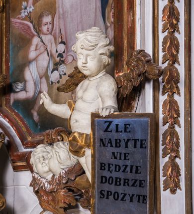 Zdjęcie nr 11: Ołtarz architektoniczny, jednokondygnacyjny, jednoosiowy, ze zwieńczeniem. Ołtarz prostopadłościenny, murowany. Retabulum o strukturze wklęsłej wzdłuż osi pionowej osadzone na niewysokim, cokole zryzalitowanym w formie pary impostów. Gzyms cokołu pośrodku ma formę półkolistego łuku nadwieszonego. Część środkowa ujęta parą wąskich filarów, licami zwróconych ukośnie na zewnątrz, wspierających wydatny gzyms osadzony na parze spływów wolutowych. Pola cokołu retabulum zdobione ornamentyką roślinną. Na impostach para figur aniołków, stojący po lewej stronie w lewej dłoni ma zwój z napisem „PATRZ / SWEGO / A NIE / PRAGNIJ / CUDZEGO”, stojący po prawej trzyma lewą ręką wspartą na podłożu tarczę z napisem „ZLE / NABYTE / NIE / BĘDZIE / DOBRZE / SPOŻYTE”. Między impostami płycina w kształcie prostokąta leżącego o wklęsłych górnych narożach i zamkniętego półkolistym łukiem nadwieszonym. W dolnej partii retabulum para uskrzydlonych główek anielskich dołem ujętych liśćmi akantu. Lica filarów zdobione motywem kampanuli. W partii belkowania, pośrodku motyw akantowego kartusza z napisem „VENI / CORONABE/RIS.”, ujętego górą, dołem i po bokach motywami uskrzydlonych główek anielskich. Zwieńczenie w formie promienistej glorii z koroną osadzoną na obłokach. Całość flankuje para siedzących na gzymsie aniołów w dynamicznych pozach. Pole części środkowej w kształcie stojącego prostokąta ujętego górą i dołem parą zwróconych do siebie półkolistych łuków nadwieszonych z uskokami, ujęte profilowaną, złoconą ramą. Wewnątrz obraz z wizerunkiem Matki Boskiej. Struktura polichromowana w kolorze białym, detal architektoniczny i ornamentyka złocone i srebrzone.