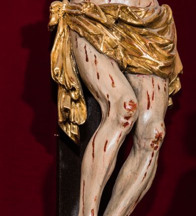 Zdjęcie nr 33: Ołtarz drewniany, architektoniczny, trójosiowy, jednokondygnacyjny ze zwieńczeniem usytuowany w połowie prezbiterium, na całej jego szerokości. Ołtarz prostopadłościenny z drewnianą mensą. Tabernakulum jest trójosiowe, osadzone na podwójnym cokole, zryzalitowane w części środkowej, podzielone kompozytowymi kolumnami, podtrzymującymi wyłamujące się nad nimi belkowanie z przerwanym przyczółkiem pośrodku. W części środkowej ruchomy tron wystawienia, wieloboczny, z rytymi literami IHS na tle glorii promienistej w jednej części i gałązkami z kwiatami w drugiej. Retabulum osadzone na wysokim cokole, z bramkami po bokach zamkniętymi łukami dwuramiennymi. Na dwiczkach malowane wizerunki św. Piotra po prawej i św. Pawła po lewej stronie. Część środkową retabulum ujmują dwie pary kompozytowych pilastrów o kanelowanych trzonech, z których środkowe cofnięte, podtrzymują przełamujące się nad nimi belkowanie i przerwany przyczółek. Zwieńczenie jest ujęte kanelowanymi pilastrami kompozytowymi z naczółkami oraz para ażurowych, ornamentacyjnych uszaków. W części środkowej jest wnęka w kształcie pionowego prostokąta zamkniętego łukiem półkolistym z rzeźbiarską grupą Ukrzyżowania z Matką Boską i św. Janem. W zwieńczeniu jest obraz „Pietas Domini&quot; w sześciobocznej ramie. W osiach bocznych nastawy znajdują się ażurowe arkady z malowanymi wizerunkami Chrystusa u słupa i Ecce Homo. Osie zwieńczone są półkolistymi przyczółkami. W osiach bocznych przeszklone galoty z kompozycją wykonaną z tkanin oraz srebrnych i złotych nici. Dekorację ornamentalną ołtarza i tabernakulum stanowią liście akantu, girlandy i rozety. Struktura utrzymana jest w kolorze brązowym, ornamentyka i detal architektoniczy są złocone. 