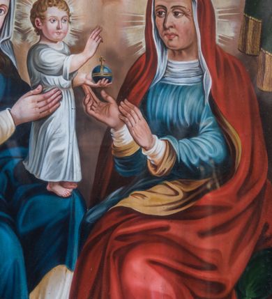 Zdjęcie nr 4: Obraz w kształcie stojącego prostokąta z przedstawieniem św. Anny Samotrzeć. Lewą stronę kompozycji zajmuje zwrócona w trzech czwartych w lewo Maria, siedząca na drewnianym fotelu z rzeźbionymi podłokietnikami. Owalną twarz charakteryzują pełne, sumarycznie opracowane rysy młodej kobiety i wzrok skierowany w stronę widza. Spod osłaniającej głowę białej chusty widoczne są długie, falowane, ciemnobrązowe włosy. Maria ubrana jest w kremową suknię ze złoconym obszyciem dekoltu. Na ramiona narzucony ma ciemnoniebieski płaszcz osłaniający nogi, na stopach są sandały, na głowie otwarta korona. Maria oburącz podtrzymuje stojące na jej lewym kolanie Dzieciątko Jezus zwrócone profilem w lewo. Głowa, o zaokrąglonej twarzy i pełnych rysach, skierowana jest w trzech czwartych w prawo. Ubrany w długą, białą suknię Jezus prawą rękę unosi w geście błogosławieństwa, w lewej trzyma kulę ziemskiego globu zwieńczoną krzyżem.     
Po prawej stronie kompozycji ukazana jest siedząca na krześle w typie faldistorium, nakrytym zieloną poduszką, św. Anna w trzech czwartych zwrócona w prawo. Owalną twarz charakteryzują wyraziste, plastycznie opracowane rysy. Święta ubrana jest w spodnią białą i wierzchnią niebieską suknię. Głowę osłania biała chusta z podwiką widoczna spod długiego, czerwonego płaszcza z żółtym podszyciem, osłaniającego także ramiona, plecy i nogi. Lekko uniesione, zgięte w łokciach ręce wyciąga przed siebie w prawo, w kierunku Dzieciątka Jezus. Głowy Marii, Jezusa i św. Anny ujmują promieniste nimby. Postaci ukazane są we wnętrzu otwierającym się na pokryte obłokami niebo. Posadzkę tworzy szachownicowy układ biało-bordowych, kwadratowych płytek, fotel Marii usytuowany jest na niskim podeście. Na pierwszym planie, po prawej stronie leży kosz z owocami: gruszką, winogronami i jabłkiem. W górnej partii kompozycję ujmuje dekoracyjnie podpięta, ciemnozielona kotara.  
