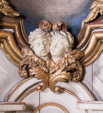 Zdjęcie nr 9: Ołtarz architektoniczny, jednokondygnacyjny, jednoosiowy, ze zwieńczeniem. Ołtarz prostopadłościenny, murowany. Retabulum o strukturze wklęsłej wzdłuż osi pionowej osadzone na niewysokim, cokole zryzalitowanym w formie pary impostów. Gzyms cokołu pośrodku ma formę półkolistego łuku nadwieszonego. Część środkowa ujęta parą wąskich filarów, licami zwróconych ukośnie w prawo, wspierających wydatny gzyms osadzony na parze spływów wolutowych. Pola cokołu retabulum zdobione ornamentyką roślinną. Na impostach para figur aniołków, stojący po lewej stronie trzyma w dłoniach zwój z napisem „KOCHAJ BOGA / I BLIZNIEGO”, stojący po prawej lewą rękę wspiera na kartuszu z napisem „POZNAJ / SIEBIE / SAMEGO”. Miedzy impostami płycina w kształcie prostokąta leżącego o wklęsłych górnych narożach i zamkniętego półkolistym łukiem nadwieszonym. W dolnej partii retabulum para uskrzydlonych główek anielskich dołem ujętych liśćmi akantu. Lica filarów zdobione motywem kampanuli. W partii belkowania, pośrodku motyw akantowego kartusza z napisem „ITE AD / IOSEPH.”, ujętego górą, dołem i po bokach motywami uskrzydlonych główek anielskich. Zwieńczenie w formie promienistej glorii z koroną zdobioną kwiatami osadzoną na obłokach. Całość flankuje para siedzących na gzymsie aniołów w dynamicznych pozach. Pole części środkowej w kształcie stojącego prostokąta ujętego górą i dołem parą zwróconych do siebie półkolistych łuków nadwieszonych z uskokami, ujęte profilowaną, złoconą ramą. Wewnątrz obraz z wizerunkiem św. Józefa. Struktura polichromowana w kolorze białym, detal architektoniczny i ornamentyka złocone i srebrzone.