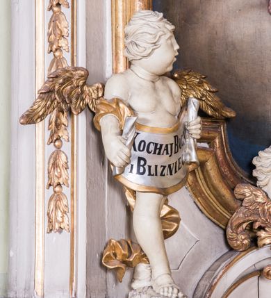 Zdjęcie nr 6: Ołtarz architektoniczny, jednokondygnacyjny, jednoosiowy, ze zwieńczeniem. Ołtarz prostopadłościenny, murowany. Retabulum o strukturze wklęsłej wzdłuż osi pionowej osadzone na niewysokim, cokole zryzalitowanym w formie pary impostów. Gzyms cokołu pośrodku ma formę półkolistego łuku nadwieszonego. Część środkowa ujęta parą wąskich filarów, licami zwróconych ukośnie w prawo, wspierających wydatny gzyms osadzony na parze spływów wolutowych. Pola cokołu retabulum zdobione ornamentyką roślinną. Na impostach para figur aniołków, stojący po lewej stronie trzyma w dłoniach zwój z napisem „KOCHAJ BOGA / I BLIZNIEGO”, stojący po prawej lewą rękę wspiera na kartuszu z napisem „POZNAJ / SIEBIE / SAMEGO”. Miedzy impostami płycina w kształcie prostokąta leżącego o wklęsłych górnych narożach i zamkniętego półkolistym łukiem nadwieszonym. W dolnej partii retabulum para uskrzydlonych główek anielskich dołem ujętych liśćmi akantu. Lica filarów zdobione motywem kampanuli. W partii belkowania, pośrodku motyw akantowego kartusza z napisem „ITE AD / IOSEPH.”, ujętego górą, dołem i po bokach motywami uskrzydlonych główek anielskich. Zwieńczenie w formie promienistej glorii z koroną zdobioną kwiatami osadzoną na obłokach. Całość flankuje para siedzących na gzymsie aniołów w dynamicznych pozach. Pole części środkowej w kształcie stojącego prostokąta ujętego górą i dołem parą zwróconych do siebie półkolistych łuków nadwieszonych z uskokami, ujęte profilowaną, złoconą ramą. Wewnątrz obraz z wizerunkiem św. Józefa. Struktura polichromowana w kolorze białym, detal architektoniczny i ornamentyka złocone i srebrzone.