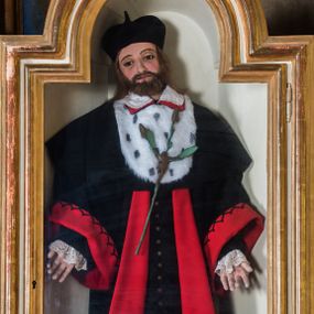 Zdjęcie nr 1: Całopostaciowa, pełnoplastyczna figura św. Jana Kantego ukazanego w pozycji stojącej i zwróconego na wprost. Lekko przechyloną na prawe ramię głowę charakteryzuje szeroka, owalna twarz o sumarycznie opracowanych wyrazistych rysach z dużymi, ciemnymi oczami, dużym nosem, wąskimi ustami oraz krótkim zarostem. Proste, brązowe włosy wspierają się na barkach mężczyzny. Święty Jan ubrany jest w czarną togę profesora akademickiego z szerokimi, czerwonymi obszyciami oraz z dużym kołnierzem z futra gronostajowego, na który wyłożony jest biały, obszyty koronką kołnierzyk spodniego ubioru. Na głowie ma biret, a na stopach czarne buty. Opuszczone wzdłuż ciała ręce rozchylone są nieznacznie na boki. Do piersi przytwierdzony jest kwiat lilii z figurą Jezusa ukrzyżowanego. 
Gablota, w której umieszczona jest figura św. Jana Kantego, ma formę prostopadłościennej szafki. Przeszklone drzwiczki, w kształcie stojącego prostokąta zamkniętego półkolistym łukiem nadwieszonym, ujęte są profilowanym, złoconym obramieniem.  
