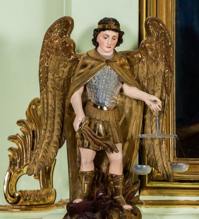 Zdjęcie nr 2: Ołtarz architektoniczny, jednokondygnacyjny, jednoosiowy, ze zwieńczeniem. Ołtarz sarkofagowy, z drewnianą mensą, pośrodku pola antepedium polichromowany monogram maryjny ujęty parą gałązek różanych. Tabernakulum w formie prostopadłościennej szafki osadzonej na zdwojonym cokole, o narożach ujętych parą skośnie ustawionych pilastrów wspierających wyłamujący się ponad nimi gzyms wieńczący, w części środkowej przybierający formę dwóch stykających się wolut. Drzwiczki są w kształcie stojącego prostokąta zamkniętego łukiem półkolistym, ujęte profilowaną, złoconą ramą. W polu płaskorzeźbiony motyw kielicha eucharystycznego. Retabulum osadzone na wysokim, zdwojonym cokole. Część środkowa ujęta parą filarów i parą cofniętych kolumn o kapitelach korynckich. Podpory wspierają wyłamujące się ponad nimi belkowanie z wydatnym gzymsem. Zwieńczenie w formie trapezoidalnej ujęte parą spływów wolutowych, zamknięte fragmentem gzymsu w postaci nawieszonego łuku odcinkowego z uskokami, dodatkowo flankowane przerwanym przyczółkiem wolutowym. Dolny cokół retabulum zdobiony motywami kogucich grzebieni, pola górnego artykułowane fragmentami ornamentu roślinnego, całość ujęta małymi uszakami skomponowanymi z kogucich grzebieni. Trzony filarów dołem zdobione rocaille’owymi kartuszami, górą podwieszenia rocaille’owe. Fryz zdobiony motywami ornamentyki roślinnej. Retabulum ujęte parą ażurowych uszaków skomponowanych z wici roślinnej i kogucich grzebieni. W zwieńczeniu, pośrodku wsparta na belkowaniu duża korona, na przerwanym przyczółku para aniołków z ulistnionymi gałązkami w podniesionych rękach. Gzyms wieńczący ujęty dołem rodzajem lambrekinu z pojedynczych liści akantu. Szczyt w formie ażurowego kartusza rocaille’owego ujęty po bokach parą płomienistych wazonów. Pole części środkowej w kształcie stojącego prostokąta zamkniętego półkolistym łukiem nawieszonym z uskokami, ujęte profilowaną, złoconą ramą. W środku obraz „Święta Rodzina” („Znalezienie Jezusa w świątyni”), na cokole retabulum para figur, po lewej św. Michał Archanioł, po prawej św. Rafał Archanioł. Pole zwieńczenia w postaci otworu w kształcie stojącego owalu wypełnione ażurową, promienistą glorią z monogramem maryjnym pośrodku ujętym wieńcem obłoków. Struktura polichromowana w odcieniu jasnej zieleni, detal architektoniczny i ornamentyka polichromowane w kolorze bordowym, złocone i srebrzone. 