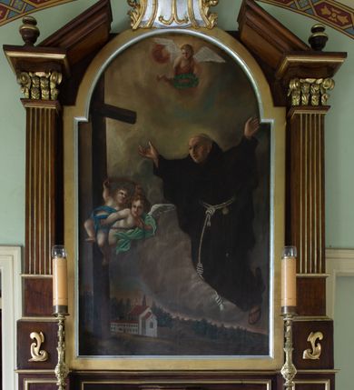 Zdjęcie nr 3: Obraz w kształcie stojącego prostokąta zamkniętego półkolistym łukiem nadwieszonym przedstawia św. Piotra z Alkantary. Zajmująca prawą stronę kompozycji, zwrócona w trzech czwartych w lewo sylwetka świętego unosi się w powietrzu. Twarz mężczyzny charakteryzuje długi, spiczasty nos, lekko rozchylone usta i dwie bruzdy na czole między oczami. Włosy przystrzyżone są w formie tonsury. Święty ubrany jest w habit franciszkański, na stopach ma sandały. Rozłożone na boki ręce wznosi do góry. Wzrok kieruje w stronę znajdującego się po lewej stronie kompozycji krzyża, z którego biją jasne, delikatne promienie. W połowie wysokości pionowej belki unosi się w powietrzu para aniołków częściowo przesłoniętych niebieską i zieloną szatą, trzymających w dłoniach łańcuch i pas nabity gwoźdźmi. Trzeci anioł, ubrany w czerwoną szatę, ukazany jest w górnej partii kompozycji, oburącz podtrzymując w dłoniach wieniec laurowy. Postaci ukazane są na tle pejzażu o obniżonej linii horyzontu, którego znaczną część stanowi pokryte gęstymi chmurami niebo, w dole zaś widoczna jest zabudowa klasztorna oraz las. W lewym, dolnym rogu płótna znajduje się sygnatura „Pinx(it) A. Kowarz / Reform. 1873.”.    