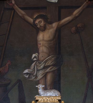 Zdjęcie nr 1: Obraz uzyskał kształt stojącego prostokąta, ujętego ramą ołtarza, która u góry jest zamknięta spłaszczonym łukiem nadwieszonym. Na ciemnym tle nieznacznie rozjaśnionym w dolnej części obrazu na drewnianym krzyżu wyobrażono wiszącego Chrystusa, któremu towarzyszą po bokach narzędzia męki Pańskiej (arma Christi). Ciało Zbawiciela o ciemnej karnacji wisi na naciągniętych ramionach ułożonych w kształcie litery V. Głowa Jezusa w koronie cierniowej jest opadnięta na prawe ramię. Chrystus ma pociągłą twarz okolona brodą i długimi włosami spływającymi na ramiona. Jego twarz charakteryzuje wydatny nos i usta oraz zamknięte oczy. Na czole, ramionach i torsie widoczne są strużki krwi. Głowę Ukrzyżowanego okala niewielki świetlisty nimb. Krew cieknie także z przebitego prawego boku. Jezus na biodrach ma założone, rozwiane, białe perizonium przewiązane sznurem. Na górnej belce krzyża przytwierdzony jest titulus w formie zwijającej się banderoli z napisem &quot;IN / RI&quot;. 
Z prawej strony krzyża widoczne są skrzyżowane ze sobą lanca i gąbka na kiju, a z lewej oparta o krzyż drabina, pod którą na kolumnie skrzyżowanej z biczem siedzi brązowo-złocisty kogut zwrócony w prawo. 