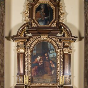 Zdjęcie nr 1: Ołtarz architektoniczny, jednokondygnacyjny, jednoosiowy, ze zwieńczeniem. Ołtarz prostopadłościenny z drewnianą mensą i drewnianym antepedium artykułowanym trzema prostokątnymi płycinami. Retabulum osadzone na nieznacznie zryzalitowanym cokole, lekko wstępującym pośrodku w kolejną partię retabulum. Część środkową ołtarza ujmuje para filarów o czworobocznym przekroju, ustawionych na tle pilastrów, osadzonych na wysokich cokołach i podtrzymujących przerwane belkowanie ze wspartym na nim przerwanym, półkolistym przyczółkiem. Część środkowa belkowania jest wyniesiona nieco wyżej. Pole części środkowej retabulum  ma kształt stojącego prostokąta zamkniętego półkolistym łukiem nadwieszonym. Osadzone na wyłamującym się pośrodku gzymsie zwieńczenie ma postać stojącego prostokąta wypełnionego płyciną z uszakami w narożach, zamkniętą trójbocznie z ośmioboku. Pole środkowe w formie wydłużonego ośmioboku. Zwieńczenie domyka szczyt z formie przerwanego, trójkątnego przyczółka usytuowanego na przerwanym belkowaniu. Środkową płycinę antepedium zdobi płaskorzeźbiony monogram SJ na tle narzędzi ciesielskich (?), boczne ornamentyka roślinna. W partiach cokołu retabulum, cokołów filarów, fryzu oraz górnych naroży części środkowej nastawy są motywy stylizowanej dekoracji roślinnej. Obramienie obrazu głównego ujmuje para wazonów z kwiatami lilii, natomiast boki zwieńczenia ołtarza para ażurowych, akantowych uszaków. W szczycie, po bokach, na przerwanym przyczółku jest para płonących wazonów, pośrodku natomiast kartusz z napisem: „ITE AD JOSEPH” oraz krzyż zdobiony wicią winnej latorośli. W polu części środkowej znajduje się przedstawienie „Pokłonu pasterzy”, w zwieńczeniu natomiast wizerunek św. Stanisława biskupa. Struktura retabulum utrzymana jest w kolorystyce pokostowanego drewna, partie detalu architektonicznego i ornamentyka są złocone. Na mensie napis „MEMENTO - FUNDATORIS / JOSEPHI&quot;.  