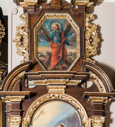 Zdjęcie nr 2: Ołtarz architektoniczny, jednokondygnacyjny, jednoosiowy, ze zwieńczeniem. Ołtarz prostopadłościenny z drewnianą mensą i drewnianym antepedium artykułowanym trzema prostokątnymi płycinami. Retabulum osadzone na lekko zryzalitowanym cokole, lekko wstępującym pośrodku w kolejną partię retabulum. Część środkową ołtarza ujmuje para filarów o czworobocznym przekroju, osadzonych na wysokich cokołach i podtrzymujących przerwane belkowanie ze wspartym na nim przerwanym, półkolistym przyczółkiem. Część środkowa belkowania jest wyniesiona nieco wyżej. Pole części środkowej ma kształt stojącego prostokąta zamkniętego półkolistym łukiem nadwieszonym. Osadzone na wyłamującym się pośrodku gzymsie zwieńczenie jest w postaci stojącego prostokąta wypełnionego płyciną z uszakami w narożach, zamkniętą trapezoidalnym łukiem. Pole środkowe jest w formie wydłużonego ośmioboku. Zwieńczenie zamyka szczyt z formie przerwanego, trójkątnego przyczółka osadzonego na przerwanym belkowaniu. Środkową płycinę antepedium zdobi płaskorzeźbiony i złocony  motyw godła zakonu franciszkanów wpisany w owal i ujęty kwiatami lilii. Boki zwieńczenia zdobi para ażurowych, ornamentalnych uszaków. W szczycie, pośrodku, na niewielkim cokoliku znajduje się złocono-srebrzony motyw z godła zakonu franciszkanów (skrzyżowane ręce na tle obłoków). W polu części środkowej umieszczono obraz przedstawiający Stygmatyzację św. Franciszka. W zwieńczeniu jest wizerunek św. Andrzeja Apostoła. Struktura retabulum utrzymana jest w kolorystyce pokostowanego drewna, partie detalu architektonicznego i ornamentyka są złocone i srebrzone. 