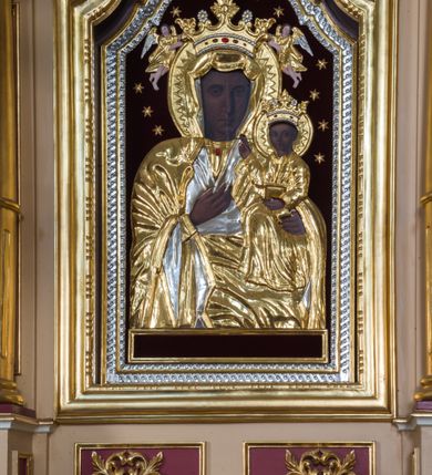 Zdjęcie nr 2: Przyścienny ołtarz drewniany, jednoosiowy ze zwieńczeniem otrzymał formę architektoniczną. Nastawa wspiera się na nowym, prostopadłościennym stipesie marmurowym z mensą, artykułowany od przodu dwiema smukłymi półkolumienkami, pomiędzy którymi umieszczono metalową i złoconą aplikację z przedstawieniem Najświętszego Serca Pana Jezusa. Na mensie ustawiono tabernakulum w formie prostopadłościennej skrzynki z drzwiczkami ozdobionymi płaskorzeźbionym kielichem z hostią, które otacza winna latorośl. Jednokondygnacyjną nastawę ustawiono na dwustrefowym cokole. Partia cokołu ozdobiona została płycinami w kształcie pionowych prostokątów, a w osi środkowej w kształcie kwadratów. Płyciny wypełniono rzeźbioną dekoracją floralną na czerwonym tle. Kondygnacja retabulum ujęta została parą złoconych kolumn, podtrzymujących wyłamane nad polem środkowym belkowanie. Kolumny o kompozytowych kapitelach ustawiono na profilowanych bazach, w jednej trzeciej wysokości przedzielone zostały opaską. W części dolnej ozdobiono je żłobkowaniem. Na belkowaniu umieszczono parę uskrzydlonych aniołków. Pole środkowe ujęte zostało w prostokątną, profilowaną ramę, zamkniętą od góry łukiem wklęsło-wypukłym z uskokami. W niej prezentowany jest obraz Matki Boskiej Częstochowskiej w drewnianej, złoconej sukience wotywnej. Po bokach nastawy umieszczono ażurowe, złocone wici akantowe pełniące role uszaków. Zwieńczenie uzyskało formę prostokąta stojącego, ujętego po bokach  dwiema lizenami i spływami wolutowymi. Wieńczy je przerywane belkowanie, na którym usytuowano parę siedzących aniołków. W polu zwieńczenia umieszczono obraz św. Agaty we wklęsło-wypukłej ramie. Natomiast szczyt zwieńczenia ozdobiono złoconym monogramem maryjnym na czerwonym tle, otoczonym wieńcem z obłoków i promienistą glorią. Strukturę nastawy pomalowano w kolorze beżowym, a ornamentykę wyzłocono i wysrebrzono.