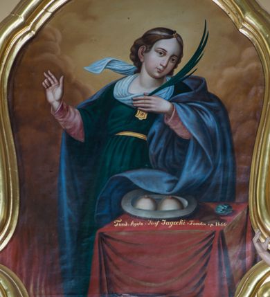 Zdjęcie nr 6: Przyścienny ołtarz drewniany, jednoosiowy ze zwieńczeniem otrzymał formę architektoniczną. Nastawa wspiera się na nowym, prostopadłościennym stipesie marmurowym z mensą, artykułowany od przodu dwiema smukłymi półkolumienkami, pomiędzy którymi umieszczono metalową i złoconą aplikację z przedstawieniem Najświętszego Serca Pana Jezusa. Na mensie ustawiono tabernakulum w formie prostopadłościennej skrzynki z drzwiczkami ozdobionymi płaskorzeźbionym kielichem z hostią, które otacza winna latorośl. Jednokondygnacyjną nastawę ustawiono na dwustrefowym cokole. Partia cokołu ozdobiona została płycinami w kształcie pionowych prostokątów, a w osi środkowej w kształcie kwadratów. Płyciny wypełniono rzeźbioną dekoracją floralną na czerwonym tle. Kondygnacja retabulum ujęta została parą złoconych kolumn, podtrzymujących wyłamane nad polem środkowym belkowanie. Kolumny o kompozytowych kapitelach ustawiono na profilowanych bazach, w jednej trzeciej wysokości przedzielone zostały opaską. W części dolnej ozdobiono je żłobkowaniem. Na belkowaniu umieszczono parę uskrzydlonych aniołków. Pole środkowe ujęte zostało w prostokątną, profilowaną ramę, zamkniętą od góry łukiem wklęsło-wypukłym z uskokami. W niej prezentowany jest obraz Matki Boskiej Częstochowskiej w drewnianej, złoconej sukience wotywnej. Po bokach nastawy umieszczono ażurowe, złocone wici akantowe pełniące role uszaków. Zwieńczenie uzyskało formę prostokąta stojącego, ujętego po bokach  dwiema lizenami i spływami wolutowymi. Wieńczy je przerywane belkowanie, na którym usytuowano parę siedzących aniołków. W polu zwieńczenia umieszczono obraz św. Agaty we wklęsło-wypukłej ramie. Natomiast szczyt zwieńczenia ozdobiono złoconym monogramem maryjnym na czerwonym tle, otoczonym wieńcem z obłoków i promienistą glorią. Strukturę nastawy pomalowano w kolorze beżowym, a ornamentykę wyzłocono i wysrebrzono.