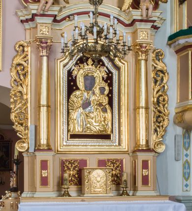 Zdjęcie nr 1: Przyścienny ołtarz drewniany, jednoosiowy ze zwieńczeniem otrzymał formę architektoniczną. Nastawa wspiera się na nowym, prostopadłościennym stipesie marmurowym z mensą, artykułowany od przodu dwiema smukłymi półkolumienkami, pomiędzy którymi umieszczono metalową i złoconą aplikację z przedstawieniem Najświętszego Serca Pana Jezusa. Na mensie ustawiono tabernakulum w formie prostopadłościennej skrzynki z drzwiczkami ozdobionymi płaskorzeźbionym kielichem z hostią, które otacza winna latorośl. Jednokondygnacyjną nastawę ustawiono na dwustrefowym cokole. Partia cokołu ozdobiona została płycinami w kształcie pionowych prostokątów, a w osi środkowej w kształcie kwadratów. Płyciny wypełniono rzeźbioną dekoracją floralną na czerwonym tle. Kondygnacja retabulum ujęta została parą złoconych kolumn, podtrzymujących wyłamane nad polem środkowym belkowanie. Kolumny o kompozytowych kapitelach ustawiono na profilowanych bazach, w jednej trzeciej wysokości przedzielone zostały opaską. W części dolnej ozdobiono je żłobkowaniem. Na belkowaniu umieszczono parę uskrzydlonych aniołków. Pole środkowe ujęte zostało w prostokątną, profilowaną ramę, zamkniętą od góry łukiem wklęsło-wypukłym z uskokami. W niej prezentowany jest obraz Matki Boskiej Częstochowskiej w drewnianej, złoconej sukience wotywnej. Po bokach nastawy umieszczono ażurowe, złocone wici akantowe pełniące role uszaków. Zwieńczenie uzyskało formę prostokąta stojącego, ujętego po bokach  dwiema lizenami i spływami wolutowymi. Wieńczy je przerywane belkowanie, na którym usytuowano parę siedzących aniołków. W polu zwieńczenia umieszczono obraz św. Agaty we wklęsło-wypukłej ramie. Natomiast szczyt zwieńczenia ozdobiono złoconym monogramem maryjnym na czerwonym tle, otoczonym wieńcem z obłoków i promienistą glorią. Strukturę nastawy pomalowano w kolorze beżowym, a ornamentykę wyzłocono i wysrebrzono.