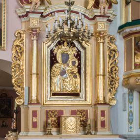 Zdjęcie nr 1: Przyścienny ołtarz drewniany, jednoosiowy ze zwieńczeniem otrzymał formę architektoniczną. Nastawa wspiera się na nowym, prostopadłościennym stipesie marmurowym z mensą, artykułowany od przodu dwiema smukłymi półkolumienkami, pomiędzy którymi umieszczono metalową i złoconą aplikację z przedstawieniem Najświętszego Serca Pana Jezusa. Na mensie ustawiono tabernakulum w formie prostopadłościennej skrzynki z drzwiczkami ozdobionymi płaskorzeźbionym kielichem z hostią, które otacza winna latorośl. Jednokondygnacyjną nastawę ustawiono na dwustrefowym cokole. Partia cokołu ozdobiona została płycinami w kształcie pionowych prostokątów, a w osi środkowej w kształcie kwadratów. Płyciny wypełniono rzeźbioną dekoracją floralną na czerwonym tle. Kondygnacja retabulum ujęta została parą złoconych kolumn, podtrzymujących wyłamane nad polem środkowym belkowanie. Kolumny o kompozytowych kapitelach ustawiono na profilowanych bazach, w jednej trzeciej wysokości przedzielone zostały opaską. W części dolnej ozdobiono je żłobkowaniem. Na belkowaniu umieszczono parę uskrzydlonych aniołków. Pole środkowe ujęte zostało w prostokątną, profilowaną ramę, zamkniętą od góry łukiem wklęsło-wypukłym z uskokami. W niej prezentowany jest obraz Matki Boskiej Częstochowskiej w drewnianej, złoconej sukience wotywnej. Po bokach nastawy umieszczono ażurowe, złocone wici akantowe pełniące role uszaków. Zwieńczenie uzyskało formę prostokąta stojącego, ujętego po bokach  dwiema lizenami i spływami wolutowymi. Wieńczy je przerywane belkowanie, na którym usytuowano parę siedzących aniołków. W polu zwieńczenia umieszczono obraz św. Agaty we wklęsło-wypukłej ramie. Natomiast szczyt zwieńczenia ozdobiono złoconym monogramem maryjnym na czerwonym tle, otoczonym wieńcem z obłoków i promienistą glorią. Strukturę nastawy pomalowano w kolorze beżowym, a ornamentykę wyzłocono i wysrebrzono.