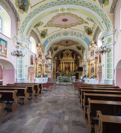 Zdjęcie nr 5: Orientowany kościół św. Wojciecha w Bulowicach obecnie uzyskał strukturę trójnawowej, trójprzęsłowej bazyliki z jednoprzęsłowym, nieco węższym prezbiterium zamkniętym spłaszczoną absydą. Na przedłużeniu dostawionych naw wybudowano półkolisty aneks zakrystyjny okalający apsydę, przepruwając go trzema półokrągłymi oknami oraz wejściem na osi. W aneksie od strony południowo-wschodniej urządzono otwartą na zewnątrz półkolistą arkadą kaplicę Ogrójcową. Od zachodu do nawy głównej przylega lekko wysunięta do przodu czworoboczna wieża flankowana dwoma, piętrowymi aneksami. Elewację masywu wieżowego artykułuje profilowany gzyms koronujący wyłamany na szerokości wieży, podtrzymujący miedziany daszek pulpitowy, dzielący ją na dwie kondygnacje. Podobny gzyms zamyka wieżę u góry, ponad którym wznosi się cebulasty hełm zwieńczony krzyżem na bani. Pod gzymsem w górnej części wieży usytuowano tarcze zegarowe oraz poniżej półokrągłe okna. W jej przyziemiu urządzono kruchtę, do której prowadzi portal uszaty z widocznym nad nim odcinkiem belkowania. Za pomocą symetrycznych spływów dostawione dwie nawy zostały połączone w spójną całość z masywem wieżowym. Do obu naw prowadzą półokrągłe arkady, w których urządzono otwarte przedsionki poprzedzające weście do kościoła. Nawę główną i prezbiterium nakryto dachem siodłowym. W jej części wschodniej nadwieszono wieżyczkę na sygnaturkę w kształcie sześciobocznej latarnii z baniastym hełmem i krzyżem. Nawy boczne i aneks zakrystyjny przykryto dachami pulpitowymi. Elewacje zewnętrzne zostały pozbawione artykulacji za wyjątkiem niskiego kamiennego cokołu obiegającego całą świątynię. Wnętrze nawy głównej zostało rozczłonkowane za pomocą opilastrowanych filarów, ponad którymi widoczne są odcinki belkowania. W tęczy kościoła zastosowano pilastry zdwojone. Nawy boczne połączono z nawą główną za pomocą mocno spłaszczonych arkad. Ponad nimi przepruto prostokątne okna zamknięte łukiem odcinkowym. Całość nawy nakryto sklepieniem żagielkowym wspartym na gurtach, zaś prezbiterium przykryto hemisferycznie. W części zachodniej nawy głównej zawieszono chór muzyczny wsparty na dwóch drewnianych filarach z drewnianym, pełnym parapetem artykułowanym czworobocznymi płycinami. Na osi środkowej parapet wyłamano na rzucie trapezu. W prezbiterium ustawiono ołtarz główny, a przy łuku tęczowym dwa ołtarze boczne. Na północnej ścianie łuku tęczowego zawieszono ambonę. Dwa niewielkie ołtarze boczne znalazły się także na zakończeniu naw bocznych.   