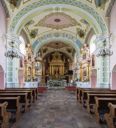 Zdjęcie nr 3: Orientowany kościół św. Wojciecha w Bulowicach obecnie uzyskał strukturę trójnawowej, trójprzęsłowej bazyliki z jednoprzęsłowym, nieco węższym prezbiterium zamkniętym spłaszczoną absydą. Na przedłużeniu dostawionych naw wybudowano półkolisty aneks zakrystyjny okalający apsydę, przepruwając go trzema półokrągłymi oknami oraz wejściem na osi. W aneksie od strony południowo-wschodniej urządzono otwartą na zewnątrz półkolistą arkadą kaplicę Ogrójcową. Od zachodu do nawy głównej przylega lekko wysunięta do przodu czworoboczna wieża flankowana dwoma, piętrowymi aneksami. Elewację masywu wieżowego artykułuje profilowany gzyms koronujący wyłamany na szerokości wieży, podtrzymujący miedziany daszek pulpitowy, dzielący ją na dwie kondygnacje. Podobny gzyms zamyka wieżę u góry, ponad którym wznosi się cebulasty hełm zwieńczony krzyżem na bani. Pod gzymsem w górnej części wieży usytuowano tarcze zegarowe oraz poniżej półokrągłe okna. W jej przyziemiu urządzono kruchtę, do której prowadzi portal uszaty z widocznym nad nim odcinkiem belkowania. Za pomocą symetrycznych spływów dostawione dwie nawy zostały połączone w spójną całość z masywem wieżowym. Do obu naw prowadzą półokrągłe arkady, w których urządzono otwarte przedsionki poprzedzające weście do kościoła. Nawę główną i prezbiterium nakryto dachem siodłowym. W jej części wschodniej nadwieszono wieżyczkę na sygnaturkę w kształcie sześciobocznej latarnii z baniastym hełmem i krzyżem. Nawy boczne i aneks zakrystyjny przykryto dachami pulpitowymi. Elewacje zewnętrzne zostały pozbawione artykulacji za wyjątkiem niskiego kamiennego cokołu obiegającego całą świątynię. Wnętrze nawy głównej zostało rozczłonkowane za pomocą opilastrowanych filarów, ponad którymi widoczne są odcinki belkowania. W tęczy kościoła zastosowano pilastry zdwojone. Nawy boczne połączono z nawą główną za pomocą mocno spłaszczonych arkad. Ponad nimi przepruto prostokątne okna zamknięte łukiem odcinkowym. Całość nawy nakryto sklepieniem żagielkowym wspartym na gurtach, zaś prezbiterium przykryto hemisferycznie. W części zachodniej nawy głównej zawieszono chór muzyczny wsparty na dwóch drewnianych filarach z drewnianym, pełnym parapetem artykułowanym czworobocznymi płycinami. Na osi środkowej parapet wyłamano na rzucie trapezu. W prezbiterium ustawiono ołtarz główny, a przy łuku tęczowym dwa ołtarze boczne. Na północnej ścianie łuku tęczowego zawieszono ambonę. Dwa niewielkie ołtarze boczne znalazły się także na zakończeniu naw bocznych.   