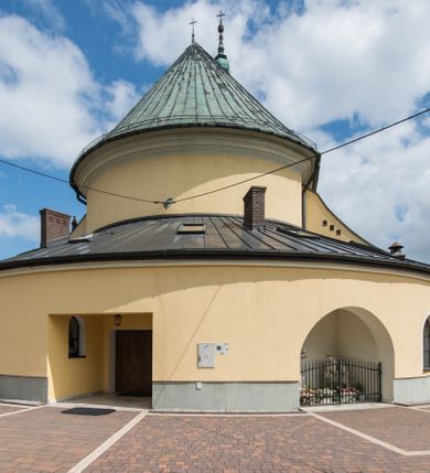 Zdjęcie nr 17: Orientowany kościół św. Wojciecha w Bulowicach obecnie uzyskał strukturę trójnawowej, trójprzęsłowej bazyliki z jednoprzęsłowym, nieco węższym prezbiterium zamkniętym spłaszczoną absydą. Na przedłużeniu dostawionych naw wybudowano półkolisty aneks zakrystyjny okalający apsydę, przepruwając go trzema półokrągłymi oknami oraz wejściem na osi. W aneksie od strony południowo-wschodniej urządzono otwartą na zewnątrz półkolistą arkadą kaplicę Ogrójcową. Od zachodu do nawy głównej przylega lekko wysunięta do przodu czworoboczna wieża flankowana dwoma, piętrowymi aneksami. Elewację masywu wieżowego artykułuje profilowany gzyms koronujący wyłamany na szerokości wieży, podtrzymujący miedziany daszek pulpitowy, dzielący ją na dwie kondygnacje. Podobny gzyms zamyka wieżę u góry, ponad którym wznosi się cebulasty hełm zwieńczony krzyżem na bani. Pod gzymsem w górnej części wieży usytuowano tarcze zegarowe oraz poniżej półokrągłe okna. W jej przyziemiu urządzono kruchtę, do której prowadzi portal uszaty z widocznym nad nim odcinkiem belkowania. Za pomocą symetrycznych spływów dostawione dwie nawy zostały połączone w spójną całość z masywem wieżowym. Do obu naw prowadzą półokrągłe arkady, w których urządzono otwarte przedsionki poprzedzające weście do kościoła. Nawę główną i prezbiterium nakryto dachem siodłowym. W jej części wschodniej nadwieszono wieżyczkę na sygnaturkę w kształcie sześciobocznej latarnii z baniastym hełmem i krzyżem. Nawy boczne i aneks zakrystyjny przykryto dachami pulpitowymi. Elewacje zewnętrzne zostały pozbawione artykulacji za wyjątkiem niskiego kamiennego cokołu obiegającego całą świątynię. Wnętrze nawy głównej zostało rozczłonkowane za pomocą opilastrowanych filarów, ponad którymi widoczne są odcinki belkowania. W tęczy kościoła zastosowano pilastry zdwojone. Nawy boczne połączono z nawą główną za pomocą mocno spłaszczonych arkad. Ponad nimi przepruto prostokątne okna zamknięte łukiem odcinkowym. Całość nawy nakryto sklepieniem żagielkowym wspartym na gurtach, zaś prezbiterium przykryto hemisferycznie. W części zachodniej nawy głównej zawieszono chór muzyczny wsparty na dwóch drewnianych filarach z drewnianym, pełnym parapetem artykułowanym czworobocznymi płycinami. Na osi środkowej parapet wyłamano na rzucie trapezu. W prezbiterium ustawiono ołtarz główny, a przy łuku tęczowym dwa ołtarze boczne. Na północnej ścianie łuku tęczowego zawieszono ambonę. Dwa niewielkie ołtarze boczne znalazły się także na zakończeniu naw bocznych.   