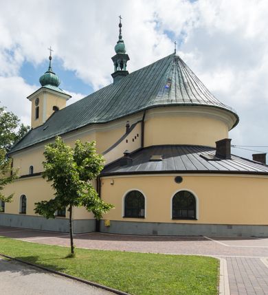 Zdjęcie nr 13: Orientowany kościół św. Wojciecha w Bulowicach obecnie uzyskał strukturę trójnawowej, trójprzęsłowej bazyliki z jednoprzęsłowym, nieco węższym prezbiterium zamkniętym spłaszczoną absydą. Na przedłużeniu dostawionych naw wybudowano półkolisty aneks zakrystyjny okalający apsydę, przepruwając go trzema półokrągłymi oknami oraz wejściem na osi. W aneksie od strony południowo-wschodniej urządzono otwartą na zewnątrz półkolistą arkadą kaplicę Ogrójcową. Od zachodu do nawy głównej przylega lekko wysunięta do przodu czworoboczna wieża flankowana dwoma, piętrowymi aneksami. Elewację masywu wieżowego artykułuje profilowany gzyms koronujący wyłamany na szerokości wieży, podtrzymujący miedziany daszek pulpitowy, dzielący ją na dwie kondygnacje. Podobny gzyms zamyka wieżę u góry, ponad którym wznosi się cebulasty hełm zwieńczony krzyżem na bani. Pod gzymsem w górnej części wieży usytuowano tarcze zegarowe oraz poniżej półokrągłe okna. W jej przyziemiu urządzono kruchtę, do której prowadzi portal uszaty z widocznym nad nim odcinkiem belkowania. Za pomocą symetrycznych spływów dostawione dwie nawy zostały połączone w spójną całość z masywem wieżowym. Do obu naw prowadzą półokrągłe arkady, w których urządzono otwarte przedsionki poprzedzające weście do kościoła. Nawę główną i prezbiterium nakryto dachem siodłowym. W jej części wschodniej nadwieszono wieżyczkę na sygnaturkę w kształcie sześciobocznej latarnii z baniastym hełmem i krzyżem. Nawy boczne i aneks zakrystyjny przykryto dachami pulpitowymi. Elewacje zewnętrzne zostały pozbawione artykulacji za wyjątkiem niskiego kamiennego cokołu obiegającego całą świątynię. Wnętrze nawy głównej zostało rozczłonkowane za pomocą opilastrowanych filarów, ponad którymi widoczne są odcinki belkowania. W tęczy kościoła zastosowano pilastry zdwojone. Nawy boczne połączono z nawą główną za pomocą mocno spłaszczonych arkad. Ponad nimi przepruto prostokątne okna zamknięte łukiem odcinkowym. Całość nawy nakryto sklepieniem żagielkowym wspartym na gurtach, zaś prezbiterium przykryto hemisferycznie. W części zachodniej nawy głównej zawieszono chór muzyczny wsparty na dwóch drewnianych filarach z drewnianym, pełnym parapetem artykułowanym czworobocznymi płycinami. Na osi środkowej parapet wyłamano na rzucie trapezu. W prezbiterium ustawiono ołtarz główny, a przy łuku tęczowym dwa ołtarze boczne. Na północnej ścianie łuku tęczowego zawieszono ambonę. Dwa niewielkie ołtarze boczne znalazły się także na zakończeniu naw bocznych.   