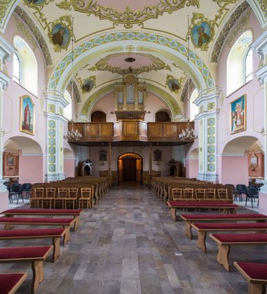 Zdjęcie nr 9: Orientowany kościół św. Wojciecha w Bulowicach obecnie uzyskał strukturę trójnawowej, trójprzęsłowej bazyliki z jednoprzęsłowym, nieco węższym prezbiterium zamkniętym spłaszczoną absydą. Na przedłużeniu dostawionych naw wybudowano półkolisty aneks zakrystyjny okalający apsydę, przepruwając go trzema półokrągłymi oknami oraz wejściem na osi. W aneksie od strony południowo-wschodniej urządzono otwartą na zewnątrz półkolistą arkadą kaplicę Ogrójcową. Od zachodu do nawy głównej przylega lekko wysunięta do przodu czworoboczna wieża flankowana dwoma, piętrowymi aneksami. Elewację masywu wieżowego artykułuje profilowany gzyms koronujący wyłamany na szerokości wieży, podtrzymujący miedziany daszek pulpitowy, dzielący ją na dwie kondygnacje. Podobny gzyms zamyka wieżę u góry, ponad którym wznosi się cebulasty hełm zwieńczony krzyżem na bani. Pod gzymsem w górnej części wieży usytuowano tarcze zegarowe oraz poniżej półokrągłe okna. W jej przyziemiu urządzono kruchtę, do której prowadzi portal uszaty z widocznym nad nim odcinkiem belkowania. Za pomocą symetrycznych spływów dostawione dwie nawy zostały połączone w spójną całość z masywem wieżowym. Do obu naw prowadzą półokrągłe arkady, w których urządzono otwarte przedsionki poprzedzające weście do kościoła. Nawę główną i prezbiterium nakryto dachem siodłowym. W jej części wschodniej nadwieszono wieżyczkę na sygnaturkę w kształcie sześciobocznej latarnii z baniastym hełmem i krzyżem. Nawy boczne i aneks zakrystyjny przykryto dachami pulpitowymi. Elewacje zewnętrzne zostały pozbawione artykulacji za wyjątkiem niskiego kamiennego cokołu obiegającego całą świątynię. Wnętrze nawy głównej zostało rozczłonkowane za pomocą opilastrowanych filarów, ponad którymi widoczne są odcinki belkowania. W tęczy kościoła zastosowano pilastry zdwojone. Nawy boczne połączono z nawą główną za pomocą mocno spłaszczonych arkad. Ponad nimi przepruto prostokątne okna zamknięte łukiem odcinkowym. Całość nawy nakryto sklepieniem żagielkowym wspartym na gurtach, zaś prezbiterium przykryto hemisferycznie. W części zachodniej nawy głównej zawieszono chór muzyczny wsparty na dwóch drewnianych filarach z drewnianym, pełnym parapetem artykułowanym czworobocznymi płycinami. Na osi środkowej parapet wyłamano na rzucie trapezu. W prezbiterium ustawiono ołtarz główny, a przy łuku tęczowym dwa ołtarze boczne. Na północnej ścianie łuku tęczowego zawieszono ambonę. Dwa niewielkie ołtarze boczne znalazły się także na zakończeniu naw bocznych.   