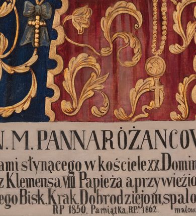 Zdjęcie nr 3: Obraz Matki Boskiej Różańcowej uzyskał kształt wydłużonego, stojącego prostokąta. Wizerunek przedstawia w półpostaci Matkę Boską z Dzieciątkiem. Maria, zwrócona delikatnie w trzech czwartych w lewo, podtrzymuje małego Jezusa obiema, skrzyżowanymi rękami na lewym ramieniu. Równocześnie Madonna w prawej dłoni trzyma białą chustę, a w lewej złoty różaniec zakończony owalnym medalionem z monogramem maryjnym. Jej rumiana twarz o jasnej karnacji jest modelowana miękkim światłocieniem. Twarz jest pociągła o delikatnych, łagodnych rysach, z prostym nosem i pełnych ustach. Matka Boska ubrana jest w ciemnogranatowy maforion podbity zielenią, lamowany i dekorowany złotymi motywami roślinno-kwiatowymi oraz imitacją zawieszonych wotów - białego orła, złotych krzyży z kokardami oraz srebrnego medalionu z kokardą. Maforion opadając na ramiona odsłania spodnią, szkarłatną suknię. Maria ma na głowie wysoką, złotą, zamkniętą koronę wypełnioną purpurą, zwieńczoną globem z krzyżykiem. Korona jest dekorowana malowaną kameryzacją. Pod szyją namalowano trzy sznury pereł przypiętych do maforiona dwiema spinkami w kształcie czteropłatkowych kwiatów. Na dolnym sznurze wisi złoty krzyżyk. Trzymane przez Madonnę Dzieciątko jest zwrócone w trzech czwartych w prawo. Mały Jezus lewą ręka podtrzymuje przy boku księgę Ewangelii z czarną okładką zdobioną złotym krzyżykiem. Natomiast nieznacznie usztywnioną i wyciągniętą przed siebie prawą rękę unosi w geście błogosławieństwa. Jezus ma okrągłą twarz o jasnej karnacji, pełnych ustach i rumianych policzkach, okoloną jasnobrązowymi, krótkimi włosami. Ubrany jest w szkarłatną tunikę u dołu bogato lamowaną złotym ornamentem roślinnym. Tunika pokryta jest drobnymi, złotymi, czterolistnymi kwiatuszkami. Na głowie ma wysoką, zamknietą, złotą koronę zwieńczoną krzyżykiem, dekorowaną malowaną kameryzacją i wypełnioną purpurą. Przy szyi małego Jezusa namalowano trzy krótkie sznury pereł dekorowane z lewej strony srebrną kokardą z długimi wstęgami. Głowy obu postaci otaczają złote nimby z wpisanymi w nie promieniami. Postacie zostały ukazane na srebrnym tle pokrytym złotą, romboidalną kratownicą. Pola kratownicy wypełniają rozety, a w miejscu przecięcia listew namalowano wielolistne kwiaty.
W dolnej części obrazu na białym tle umieszczono czarny napis: N(AJŚWIĘTSZA) M(ARIA) PANNA RÓŻAŃCOWA / Według obrazu cudami słynącego w kościele XX. Dominikanów w Krakowie / poświęconego przez Klemensa VIII Papieża a przywiezionego przez Kard(dynała) Ber / narda Maciejowskiego Bisk(upa) Krak(owskiego) Dobrodziejom spalonego kościoła S(więtej) Trójcy / R(oku) P(ańskiego) 1850. Pamiątka R(oku) P(ańskiego) 1862 malowany R(oku) P(ańskiego) 1866.