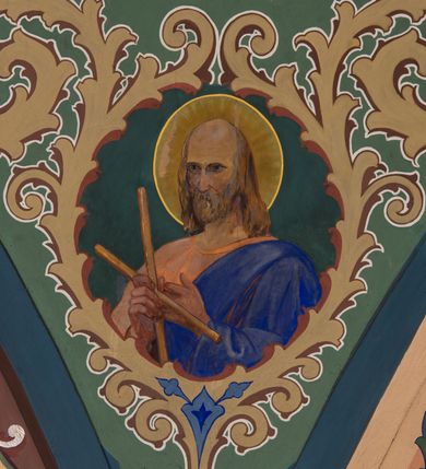 Zdjęcie nr 20: W prezbiterium w absydzie do dwóch trzecich wysokości ściany dekoracja roślinno-geometryczna z motywami kwiatowymi w kolorach zielono-turkusowym oraz złotym; powyżej dwa anioły na tle niebieskiego nieba z rozetami, całość zakończona zgeometryzowaną glorią promienistą uzupełnioną motywami kwiatowymi. 
Ściany boczne prezbiterium w kolorze jasnego różu; na ścianie tarczowej południowej medalion z kielichem i hostią w glorii promienistej. Na pilastrach, gurtach sklepiennych i w rozglifieniach okien symetryczna dekoracja roślinna. Na sklepieniu jasnopomarańczowe pole, w którego centrum znajduje się medalion z przedstawieniem Veraicon w glorii promienistej uzupełnionej motywami roślinnymi. 
Łuk tęczowy pokryty ornamentem roślinnym z motywami kłosów zbóż, na niebieskim tle, na środku łuku przedstawienie pelikana w gnieździe. Po wewnętrznej stronie łuku malatura w postaci fantazyjnego ornamentu roślinnego na beżowym tle. 
Ściany nawy gładkie, w kolorze zgaszonej, jasnej zieleni; z malowanymi zacheuszkami. W rozglifieniach okien symetryczna, stylizowana dekoracja arabeskowa na pomarańczowym i żółtym tle. Pilastry i łuki pokryte różnokolorowym, fantazyjnym ornamentem roślinnym. Sklepienia w każdym przęśle z wydzielonymi jasnożółtymi, owalnymi polami, w których centrum znajdują się niebieskie medaliony z przedstawieniem gorejącego serca lub monogramu IHS, w koronie cierniowej, w wieńcu z dekoracji roślinnej i w fioletowej glorii promienistej. W przyłuczach sklepień medaliony z przedstawieniami popiersi 12 apostołów, po czterech w każdym przęśle, ujętych żółtą wicią roślinną, na zielonym tle. Gurty sklepienne z motywem krzyży na żółto-pomarańczowym tle. 
Parapet chóru muzycznego i wspierające go arkady podzielone na malowane pola i płyciny wypełnione fantazyjnym ornamentem roślinnym. Na osi balustrady chóru przedstawienie liry. W podłuczu środkowej arkady pod chórem oko Opatrzności w wielobarwnej, stylizowanej glorii promienistej. 
Na ścianie zachodniej dwie półkoliście zamknięte nisze z przedstawieniami z lewej strony św. Cecylii grającej na organach, zaś z prawej króla Dawida grającego na harfie, na jasnoniebieskim tle. W rozglifieniach nisz stylizowana dekoracja geometryczno-roślinna. 
