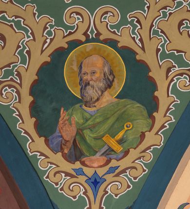 Zdjęcie nr 21: W prezbiterium w absydzie do dwóch trzecich wysokości ściany dekoracja roślinno-geometryczna z motywami kwiatowymi w kolorach zielono-turkusowym oraz złotym; powyżej dwa anioły na tle niebieskiego nieba z rozetami, całość zakończona zgeometryzowaną glorią promienistą uzupełnioną motywami kwiatowymi. 
Ściany boczne prezbiterium w kolorze jasnego różu; na ścianie tarczowej południowej medalion z kielichem i hostią w glorii promienistej. Na pilastrach, gurtach sklepiennych i w rozglifieniach okien symetryczna dekoracja roślinna. Na sklepieniu jasnopomarańczowe pole, w którego centrum znajduje się medalion z przedstawieniem Veraicon w glorii promienistej uzupełnionej motywami roślinnymi. 
Łuk tęczowy pokryty ornamentem roślinnym z motywami kłosów zbóż, na niebieskim tle, na środku łuku przedstawienie pelikana w gnieździe. Po wewnętrznej stronie łuku malatura w postaci fantazyjnego ornamentu roślinnego na beżowym tle. 
Ściany nawy gładkie, w kolorze zgaszonej, jasnej zieleni; z malowanymi zacheuszkami. W rozglifieniach okien symetryczna, stylizowana dekoracja arabeskowa na pomarańczowym i żółtym tle. Pilastry i łuki pokryte różnokolorowym, fantazyjnym ornamentem roślinnym. Sklepienia w każdym przęśle z wydzielonymi jasnożółtymi, owalnymi polami, w których centrum znajdują się niebieskie medaliony z przedstawieniem gorejącego serca lub monogramu IHS, w koronie cierniowej, w wieńcu z dekoracji roślinnej i w fioletowej glorii promienistej. W przyłuczach sklepień medaliony z przedstawieniami popiersi 12 apostołów, po czterech w każdym przęśle, ujętych żółtą wicią roślinną, na zielonym tle. Gurty sklepienne z motywem krzyży na żółto-pomarańczowym tle. 
Parapet chóru muzycznego i wspierające go arkady podzielone na malowane pola i płyciny wypełnione fantazyjnym ornamentem roślinnym. Na osi balustrady chóru przedstawienie liry. W podłuczu środkowej arkady pod chórem oko Opatrzności w wielobarwnej, stylizowanej glorii promienistej. 
Na ścianie zachodniej dwie półkoliście zamknięte nisze z przedstawieniami z lewej strony św. Cecylii grającej na organach, zaś z prawej króla Dawida grającego na harfie, na jasnoniebieskim tle. W rozglifieniach nisz stylizowana dekoracja geometryczno-roślinna. 
