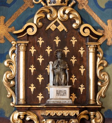 Zdjęcie nr 14: W prezbiterium w absydzie do dwóch trzecich wysokości ściany dekoracja roślinno-geometryczna z motywami kwiatowymi w kolorach zielono-turkusowym oraz złotym; powyżej dwa anioły na tle niebieskiego nieba z rozetami, całość zakończona zgeometryzowaną glorią promienistą uzupełnioną motywami kwiatowymi. 
Ściany boczne prezbiterium w kolorze jasnego różu; na ścianie tarczowej południowej medalion z kielichem i hostią w glorii promienistej. Na pilastrach, gurtach sklepiennych i w rozglifieniach okien symetryczna dekoracja roślinna. Na sklepieniu jasnopomarańczowe pole, w którego centrum znajduje się medalion z przedstawieniem Veraicon w glorii promienistej uzupełnionej motywami roślinnymi. 
Łuk tęczowy pokryty ornamentem roślinnym z motywami kłosów zbóż, na niebieskim tle, na środku łuku przedstawienie pelikana w gnieździe. Po wewnętrznej stronie łuku malatura w postaci fantazyjnego ornamentu roślinnego na beżowym tle. 
Ściany nawy gładkie, w kolorze zgaszonej, jasnej zieleni; z malowanymi zacheuszkami. W rozglifieniach okien symetryczna, stylizowana dekoracja arabeskowa na pomarańczowym i żółtym tle. Pilastry i łuki pokryte różnokolorowym, fantazyjnym ornamentem roślinnym. Sklepienia w każdym przęśle z wydzielonymi jasnożółtymi, owalnymi polami, w których centrum znajdują się niebieskie medaliony z przedstawieniem gorejącego serca lub monogramu IHS, w koronie cierniowej, w wieńcu z dekoracji roślinnej i w fioletowej glorii promienistej. W przyłuczach sklepień medaliony z przedstawieniami popiersi 12 apostołów, po czterech w każdym przęśle, ujętych żółtą wicią roślinną, na zielonym tle. Gurty sklepienne z motywem krzyży na żółto-pomarańczowym tle. 
Parapet chóru muzycznego i wspierające go arkady podzielone na malowane pola i płyciny wypełnione fantazyjnym ornamentem roślinnym. Na osi balustrady chóru przedstawienie liry. W podłuczu środkowej arkady pod chórem oko Opatrzności w wielobarwnej, stylizowanej glorii promienistej. 
Na ścianie zachodniej dwie półkoliście zamknięte nisze z przedstawieniami z lewej strony św. Cecylii grającej na organach, zaś z prawej króla Dawida grającego na harfie, na jasnoniebieskim tle. W rozglifieniach nisz stylizowana dekoracja geometryczno-roślinna. 
