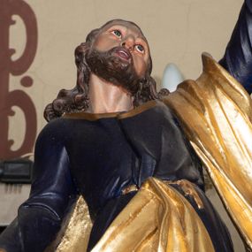 Zdjęcie nr 1: Rzeźba pełna, ustawiona na niskiej podstawie. Święty zwrócony frontalnie, odchylony, z głową skierowaną w górę, w wykroku. Lewą rękę unosi wysoko w górę, prawą w bok, w dłoni trzyma klucze. Twarz ma szczupłą, o dużych oczach skierowanych w górę, garbatym nosie oraz pełnych, otwartych ustach; okoloną krótką, kręconą brodą oraz kręconymi włosami, sięgającymi ramion. Święty ubrany w ciemnoniebieską tunikę ze złoconymi lamówkami, przepasaną w talii oraz złocony płaszcz zarzucony na lewe przedramię i zawiązany w pasie z przodu postaci. Na stopach ma sandały. Polichromia ciała naturalistyczna.
