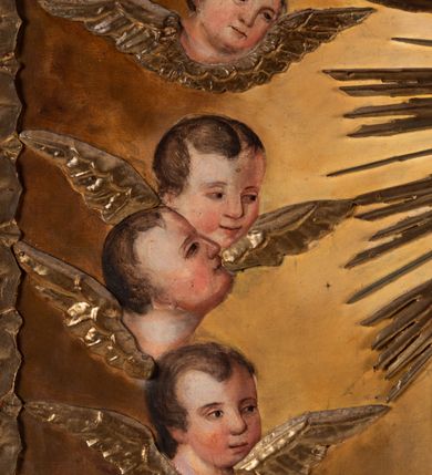 Zdjęcie nr 20: Feretron tworzy dwustronne pole obrazowe w kształcie stojącego prostokąta, zamknięte w ramę dekorowaną motywem palmetowym, ujęte z trzech stron ornamentalnym, płaskorzeźbionym obramieniem utworzonym ze stylizowanej wici roślinnej. Obramieni na górnej ramie flankuje owalny medalion z monogramem maryjnym na awersie i chrystogramem "IHS" na rewersie. Całość przymocowana jest do prostopadłościennego, wydłużonego i profilowanego postumentu przeprutego po bokach otworami na drążki do noszenia. Pomiędzy nimi umiejscowiono niewielki ornament roślinny. W centrum kompozycji, w obrazie z Matką Boską Pocieszenia, ukazano siedzącą frontalnie na brązowo-białych obłokach Madonnę z Dzieciątkiem. Maryja ma lekko pochyloną głowę w lewo, ujętą w trzech czwartych. Lewą ręką podtrzymuje siedzącego na jej kolanach małego Jezusa, w prawej, uniesionej i zgiętej w łokciu trzyma brązowy pasek. Madonna ma owalną twarz okoloną brązowymi włosami, wysokie czoło, wydatny, prosty nos i usta. Jej spojrzenie skierowane jest przed siebie. Ma odsłoniętą głowę z długimi, brązowymi włosami spływającymi na ramiona. Na głowie ma złotą, zamknietą koronę z krzyżykiem. Ubrana jest w suknię i płaszcz narzucony na ramiona i częściowo okrywający połą jej kolana. Głowę Marii otaczają złote promienie. Siedzące na jej kolanach Dzieciątko zostało ukazane frontalnie. Jezus w opuszczonej, lewej ręce trzyma pasek, natomiast wyciągniętą prawą błogosławi. Ma owalną twarz z wysokim czołem, rumiane policzki, wydatny nos i usta. Jego spojrzenie skierowane jest w stronę widza. Na głowie ma krótkie, jasnobrązowe włosy odsłaniające lewe ucho. Ubrany jest w luźną tunikę, spod której widać bosą stopę. Po bokach Matki Boskiej na jasnoochrowo-brązowym tle ukazano w rzędach po pięć uskrzydlonych główek anielskich. Poniżej Madonny z lewej strony obrazu klęczy św. Augustyn, a z prawej św. Monika. Oboje zostali ujęci w trzech czwartych. Augustyn w zakonnej kukuli z pastorałem w prawej ręce trzyma otrzymanym od Marii pasek w wyciągniętej lewej. Jest to starszy mężczyzna o twarzy z jasną karnacją, wydatnym nosie i ustach otoczoną krótkimi włosami z wyciętą tonsurą i podobnym zarostem. Z jego lewej strony przy kolanach leży mitra biskupia i zamknięta księga. Z kolei św. Monika ujęta została klęcząc w profilu w lewo. Ma pociągłą twarz o jasnej karnacji, z drobnym nosem i ustami. Jej głowę okrywa chusta spływająca na obfitą suknię. Na obrazie partie szat wszystkich przedstawionych osób oraz skrzydła anielskich główek i atrybuty św. Augustyna okrywają złocone i srebrzone sukienki wotywne, odsłaniające tylko partie twarzy i dłoni. Także wokół Madonny umieszczono ostro zakończone i profilowane złocone promienie. Na rewersie w polu obrazowym feretronu ukazano Matkę Boską Różańcową w otoczeniu tajemnic różańcowych. W centrum kompozycji na jasnym tle przedstawiono stojącą Madonnę z Dzieciątkiem, która depcze węża. Ujęta frontalnie w kontrapoście Maria obiema rękami podtrzymuje na prawym ramieniu Dzieciątko. Ma owalną twarz o jasnej karnacji, prostym nosie i wąskich ustach, o spojrzeniu skierowanym na widza. Ubrana jest w maforion odsłaniający spodnią suknię. Matka Boska stoi na półksiężycu depcząc węża trzymającego w paszczy jabłko. Trzymane przez nią Dzieciątko ujęto w trzech czwartych w prawo. Prawą ręką zdaje się błogosławić lewą wyciąga w stronę twarzy matki. Jezus ma pucułowatą twarz o jasnej karnacji i rumianych policzkach z drobnym nosem i ustami. Jego głowę otaczają krótkie, brązowe włosy odsłaniające lewe ucho. Mały Jezus ubrany jest w tunikę przepasaną w pasie. Szaty Marii i Dzieciątka przykrywa wotywna, złocona sukienka powtarzająca zapewne układ malowanych draperii. Ponad głową Madonny dwóch aniołów unosi zamkniętą koronę, trzymając w dłoniach lilie. Także ich szaty oraz korona pokryte są złoconymi sukienkami wotywnymi. Wokół Matki Boskiej rozmieszczono owalne medaliony malowane w piętnaście tajemnic Różańca świętego z podpisami każdego przedstawienia. Ich narracja rozpoczyna się nad głową Madonny. Każda ze scen oparta jest o kilkuosobową kompozycję. Idąc w lewo namalowano: Zwiastowanie Marii, Nawiedzenie św. Elżbiety, Boże Narodzenie, Ofiarowanie w świątyni, Znalezienie w świątyni, Modlitwa w Ogrójcu, Biczowanie, Cierniem ukoronowanie, Niesienie krzyża, Ukrzyżowanie, Zmartwychwstanie, Wniebowstąpienie, Zesłanie Ducha Świętego, Wniebowzięcie Marii, Ukoronowanie Marii w niebie. Pomiędzy medalionami namalowano czerwone róże, a wszystkie medaliony obramienia ciemny różaniec, zakończony krzyżykiem widocznym na osi kompozycji. 