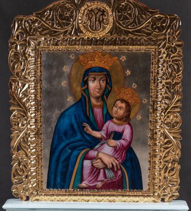 Zdjęcie nr 1: Feretron tworzy dwustronne pole obrazowe w kształcie stojącego prostokąta, zamknięte w ramę dekorowaną motywem palmetowym, ujęte z trzech stron ornamentalnym, płaskorzeźbionym obramieniem utowrzonym z kwiatów i liści. Obramieni na górnej ramie flankuje owalny medalion monogramem maryjnym na awersie i chrystogramem "IHS" na rewersie. Całość przymocowana jest do prostopadłościennego, wydłużonego i profilowanego postumentu przeprutego po bokach otworami na drążki do noszenia. Dolną krawędź postumentu dekoruje płaskorzeźbiony ornament z motywem liścia palmetowego. Na awersie feretronu usytuowano wizerunek Matki Boskiej Śnieżnej. Obraz uzyskał kształt stojącego prostokąta. W centrum kompozycji przedstawiono frontalnie w półpostaci Matkę Boską z Dzieciątkiem na lewym ramieniu. Maria podtrzymuje małego Jezusa obiema, skrzyżowanymi rękami, trzymając równocześnie w prawej dłoni chustę. Jej głowa została ujęta nieznacznie w trzech czwartych w prawo. Madonna ma pociągłą twarz o jasnej karnacji i mocnych rysach, z wydatnym nosem i pełnych ustach. Ubrana jest w niebieski maforion lamowany złotą taśmą i podbity grynszpanową zielenią. Spod maforionu widać różową suknię. Trzymane przez Madonnę Dzieciątko jest zwrócone w jej stronę w trzech czwartych. Mały Jezus lewą ręka podtrzymuje przy boku księgę Ewangelii. Natomiast nieznacznie usztywnioną i wyciągniętą przed siebie prawą rękę unosi w geście błogosławieństwa. Jezus ma okrągłą twarz o jasnej karnacji, pełnych ustach i rumianych policzkach, okoloną jasnobrązowymi, włosami sięgającymi ramion. Ubrany jest w różowobiałą tunikę lamowaną złocistą taśmą pod szyją i przy rękawach. Spod tuniki widać jego bose stopy. Maria i Jezus na głowie mają złote korony ze sterczynami utworzonymi ze stylizowanych lilii heraldycznych. Głowy obu postaci otaczają świetliste nimby oraz dwanaście gwiazdek. Całość wyobrażono na posrebrzonym tle. Na rewersie umieszczono scenę koronacji Marii na złotym tle. Obraz uzyskał kształt stojącego prostokąta. W centrum kompozycji ukazano klęczącą na obłokach Madonnę pomiędzy widocznym z lewej strony Chrystusem, a Bogiem Ojcem z prawej. Matka Boska została ujęta w trzech czwartych w prawo. Ma lekko pochyloną głowę oraz modlitewnie złożone na piersi ręce. Marię przedstawiono jako młodą dziewczynę z odkrytą głową otoczoną brązowymi, długimu włosami spływającymi na plecy. Jej twarz o jasnej karnacji, okrągłych, rumianych policzkach charkateryzuje prosty nos i wąskie usta. Ubrana jest w różową suknię z dużym dekoltem obszytym złotą taśmą oraz w niebieski płaszcz zsunięty na oba przedramienia. Z prawej strony wyobrażono siędzącego na brązowobiałych obłokach Boga Ojca. Jest to sędziwy starzec ujęty w trzech czwartych w prawo. Prawą ręką podtrzymuję koronę nad głową Marii, a w lewej opartej o widoczny we fragmencie niebieski glob trzyma złote berło. Ma pociągłą twarz z wysokim czołem i jasną karnacją okoloną siwymi włosami i długą brodą. Ubrany jest w grynszapnową tunikę przewiązaną w pasie i przerzucony przez ramiona ochrowy płaszcz podbity jasnym fioletem. Jego głowę ukazno na tle żółtego trójkąta. Z lewej strony Madonny przedstawiono siedzącego na obłokach Chrystusa ujętego w trzech czwartych w prawo z głową widoczną w profilu. Zbawiciel lewą ręką podtrzymuje nad głową Marii złotą koronę, a w prawej drewniany krzyż oparty o ramię. Ma pociągłą twarz o jasnej karnacji, migdałowych oczach, wydatnym nosie i ustach, otoczoną krótką, brązową brodą i włosami spływającymi na plecy. Jego nagi tors z zaznaczoną raną prawego boku okrywa czerwona tkanina przerzucona przez lewe ramię i zasłaniając jego nogi. Ponad koroną trzymaną przez Boga Ojca i Chrystusa widoczna jest gołębica Ducha Świętego. 