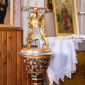Zdjęcie nr 1: Chrzcielnica w typie kielichowym na niewysokiej stopie w kształcie prostopadłościanu o ściętych narożach, przymocowanej do trzonu na rzucie ośmioboku, z gruszkowym nodusem pośrodku, ujętym u dołu parą, a u góry jednym pierścieniem, zwieńczonym pierścieniem i wałkiem. Czarę chrzcielnicy na rzucie koła, pokrytą polichromowanym wzorem geometrycznym, dołem zdobi płaskorzeźbiony motyw ornamentyki akantowej, górą obiega wałek, znajdujący się tuż pod lekko wywiniętym wylewem. Ażurowa czasza osadzona jest na niewysokiej podstawie na rzucie koła. Tworzą ją cztery kabłąki w postaci pary małżowin w kształcie litery „C”, wspierające zwieńczenie w formie zamkniętej korony. Struktura chrzcielnicy utrzymana jest w odcieniach bordo, ciemnej zieleni oraz beżu, detale oraz czasza są złocone i srebrzone.        

Całość osadzona jest na niewysokiej, drewnianej podstawie na rzucie koła, wspartej na czterech metalowych nóżkach. 
