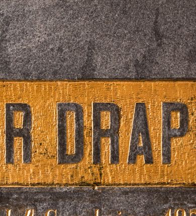 Zdjęcie nr 1: Epitafium w formie kamiennej tablicy w kształcie leżącego prostokąta, przymocowanej w narożach czterema śrubami o zakończeniach w formie rozetek. W górnej partii, na złoconym, prostokątnym tle jest napis „ARTUR DRAPELLA”, natomiast poniżej: „*d(nia) 4. Grudnia r(oku) 1871, / +d(nia) 16. Lutego r[oku] 1892 / Drogi synu! / spij w spokoju.”. 

