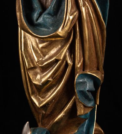 Zdjęcie nr 14: Rzeźba pełnoplastyczna, przyścienna. Przedstawienie Matki Boskiej z Dzieciątkiem ukazanej frontalnie, w całej postaci, w postawie stojącej, z ugiętymi w łokciach rękami; w prawej dłoni trzyma przed sobą berło, prawą obejmuje Dzieciątko. Twarz owalna, o jasnej karnacji, drobnych rysach, z wysokim czołem, okolona włosami spływającymi na ramiona i plecy. Na głowie złota otwarta korona (wtórna). Ubrana w długą suknię z długimi rękawami, zmarszczoną pionowymi równoległymi fałdami, przewiązaną w pasie. Na ramiona nałożony złoty płaszcz z błękitną podszewką, okrywający całą postać i odwijający się pod prawą ręką i przy podstawie okazałymi fałdami muszlowymi. Nagie Dzieciątko o pulchnym ciele siedzi na lewym przedramieniu Matki. Kulista głowa na krótkiej szyi okolona kędzierzawymi włosami. Prawą dłonią błogosławi, w lewej trzyma kulę. 