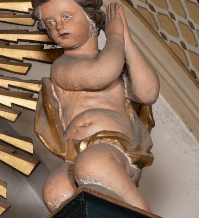 Zdjęcie nr 10: Przyścienna, jednoosiowa i jednokondygnacyjna struktura ołtarza uzyskała kształt nastawy architektonicznej ze zwieńczeniem. Drewniany stipes ołtarzowy przyjął formę leżącego prostopadłościanu podtrzymującego mensę, ustawionego na dwustopniowym podeście. Drewniane antependium ujęto profilowaną ramą z polem udekorowanym monogramem maryjnym w centrum, otoczonym rzeźbionym różańcem przy zewnętrznych krawędziach. Stipes przylega do  trzystrefowego, wysokiego cokołu wspierającego nastawę. Kolejne strefy zostały wydzielone za pomocą poziomych profili. Drugą i trzecią strefę cokołu ozdobiono obramionymi, prostokątnymi płycinami - w drugiej strefie w kształcie stojących prostokątów, a w trzeciej leżących. Kondygnację wsparto na zdwojonych pilastrach o korynckich głowicach, przed którymi ustawiono korynckie kolumny podtrzymujące imposty ze wspartym na nim przerwanym belkowaniem wyłamanym na ich osi. Na belkowaniu widoczne są dwa półkoliste przyczółki z klęczącymi na nich dwoma aniołkami. W kondygnacji pomiędzy pilastrami i kolumnami usytuowano pole obrazowe obramienione profilowaną ramą w kształcie stojącego prostokąta zwieńczonego nadwieszonym łukiem odcinkowym. Rama ujmuje obraz przedstawiający św. Józefa z Dzieciątkiem Jezus. Kondygnację flankują ustawione na cokole retabulum figury św. Dominika i św. Katarzyny ze Sieny. Na osi pola obrazowego w kondygnacji, zawieszono na belkowaniu fantazyjny kartusz z monogramem maryjnym na tle obłoków z uskrzydlonymi główkami anielskimi, powyżej którego w zwieńczeniu retabulum znalazła się promienista gloria z chrystogramem "IHS" otoczonym koliście obłokami. Litery monogramu utworzono z płaskorzeźbionych, złoconych róż w niebieskim polu. W centrum litery "H" na konsolce ukazano w pełnej postaci stojące Dzieciątko Jezusa z rozłożonymi rękami. Struktura ołtarza została pomalowana na czarno, natomiast kolumny, głowice pilastrów, profile architektoniczne oraz glorię i skrzydła aniołków wyzłocono, obłoki w glorii posrebrzono, a pole antependium i glorii pomalowano na niebiesko. Rzeźby świętych dominikańskich, aniołów i Dzieciątka Jezus uzyskały naturalistyczną polichromię.  
