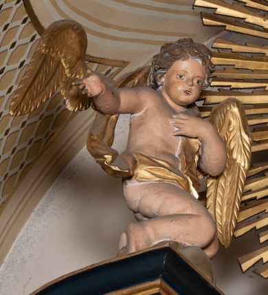 Zdjęcie nr 11: Przyścienna, jednoosiowa i jednokondygnacyjna struktura ołtarza uzyskała kształt nastawy architektonicznej ze zwieńczeniem. Drewniany stipes ołtarzowy przyjął formę leżącego prostopadłościanu podtrzymującego mensę, ustawionego na dwustopniowym podeście. Drewniane antependium ujęto profilowaną ramą z polem udekorowanym monogramem maryjnym w centrum, otoczonym rzeźbionym różańcem przy zewnętrznych krawędziach. Stipes przylega do  trzystrefowego, wysokiego cokołu wspierającego nastawę. Kolejne strefy zostały wydzielone za pomocą poziomych profili. Drugą i trzecią strefę cokołu ozdobiono obramionymi, prostokątnymi płycinami - w drugiej strefie w kształcie stojących prostokątów, a w trzeciej leżących. Kondygnację wsparto na zdwojonych pilastrach o korynckich głowicach, przed którymi ustawiono korynckie kolumny podtrzymujące imposty ze wspartym na nim przerwanym belkowaniem wyłamanym na ich osi. Na belkowaniu widoczne są dwa półkoliste przyczółki z klęczącymi na nich dwoma aniołkami. W kondygnacji pomiędzy pilastrami i kolumnami usytuowano pole obrazowe obramienione profilowaną ramą w kształcie stojącego prostokąta zwieńczonego nadwieszonym łukiem odcinkowym. Rama ujmuje obraz przedstawiający św. Józefa z Dzieciątkiem Jezus. Kondygnację flankują ustawione na cokole retabulum figury św. Dominika i św. Katarzyny ze Sieny. Na osi pola obrazowego w kondygnacji, zawieszono na belkowaniu fantazyjny kartusz z monogramem maryjnym na tle obłoków z uskrzydlonymi główkami anielskimi, powyżej którego w zwieńczeniu retabulum znalazła się promienista gloria z chrystogramem "IHS" otoczonym koliście obłokami. Litery monogramu utworzono z płaskorzeźbionych, złoconych róż w niebieskim polu. W centrum litery "H" na konsolce ukazano w pełnej postaci stojące Dzieciątko Jezusa z rozłożonymi rękami. Struktura ołtarza została pomalowana na czarno, natomiast kolumny, głowice pilastrów, profile architektoniczne oraz glorię i skrzydła aniołków wyzłocono, obłoki w glorii posrebrzono, a pole antependium i glorii pomalowano na niebiesko. Rzeźby świętych dominikańskich, aniołów i Dzieciątka Jezus uzyskały naturalistyczną polichromię.  