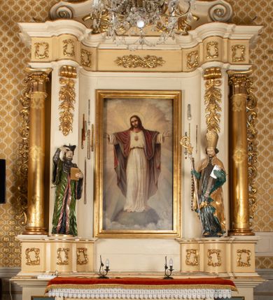 Zdjęcie nr 2: Przyścienny, jednokondygnacyjny ołtarz boczny uzyskał strukturę architektoniczną ze zwieńczeniem. Drewniany stipes ołtarzowy w formie prostopadłościanu, ustawiony na jednostopniowym podeście, podtrzymuję mensę. Jego lico zdobi aplikacja symbolizująca płonące Serce Jezusa w promienistym otoku. Retabulum ustawiono na wysokim dwupoziomowym cokole. Pierwszy poziom tworzy prostopadłościenna struktura dekorowana dwiema płycinami w formie stojącego prostokąta zwieńczona profilowanym gzymsem. Nad drugi poziomie znalazła się przerwana w osi środkowej wklęsło-wypułka strefa cokołowa z płycinami ozdobionymi czworobokami ze stylizowanego ornamentu roślinnego. Wspiera ona flankujące kondygnację dwa pilastry z głowicami wolutowymi o trzonach zdobionych zwisami roślinnymi na wstęgach oraz dwie kolumny z kapitelami kompozytowymi. Podpory podtrzymują belkowanie półkoliście wyłamane na osi pilastrów z rozbudowanym architrawem, powtarzającym układ górnej strefy cokołowej. Po bokach nastawy widoczne są dwa uszaki zredukowane do ażurowej wici roślinnej. Zwieńczenie uzyskało kształt leżącego prostokąta z wklęsłymi bokami przechodzącymi w spływy wolutowe. Wieńczy je gzyms koronujący w kształcie nadwieszonego łuku odcinkowego z podwieszonym ornamentem liściastym. Na gzymsie ustawiono na osi krzyż. W polu kondygnacji umieszczono pole obrazowe w kształcie stojącego prostokąta zamknięte profilowaną ramą z wyobrażeniem Najświętszego Serca Pana Jezusa. Ujmuje go figura św. Jana Kantego i św. Biskupa ustawione na półkoliście wyłamanych fragmentach cokołu. W zwieńczenia umieszczono w owalu obraz św. Tekli. Strukturę polichromowano w kolorze kości słoniowej oraz beżowej, natomiast kolumny, partie ornamentu, profile pozłocono. 