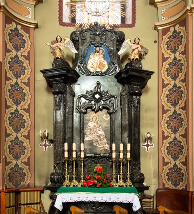 Zdjęcie nr 2: Ołtarz architektoniczny, jednokondygnacyjny ze zwieńczeniem. Mensę ujmują dwa ukośnie ustawione cokoły z wolutami, na których posadowione ukośnie zdwojone pilastry z liściastymi wolutami u podstawy i z liściastymi wolutami w funkcji kapiteli, dźwigających odcinki belkowania. Nad belkowaniem klęczące na wolutach anioły. Zwieńczenie ujęte spływami wolutowymi zakończone fantazyjnymi wolutami z liściem. W centrum ołtarza pole w formie stojącego prostokąta ujęte profilowaną ramą, zwieńczone liściastymi wolutami i rozłożystym kwiatem; w polu obraz z przedstawieniem Matki Boskiej z Dzieciątkiem. W zwieńczeniu pole wpisane w owal, obwiedzione profilowanym obramieniem z wolutami; w polu płaskorzeźba z przedstawieniem św. Józefa z Dzieciątkiem. W dolnej części nastawy inskrypcja: „HOC ALTARE EXSTRUCTUM / A(NNO) D(OMINI) M. DCCC, XXX, VIII. / SUMPTU R(EVERENDI) D(OMINI) ANTONII / GRALEWSKI / CURATI BIELANENSIS. / PER / D(OMINUM) PAULINUM CZEKIERSKI / ARTISTAM”.