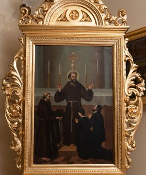 Zdjęcie nr 1: Czworoboczne pole obrazowe w kształcie stojącego prostokąta, ujęte w dekoracyjną ramę ze zwieńczeniem oraz ażurową wicią akantowo-kwiatową po bokach, ustawiono na postumencie w kształcie leżącego prostopadłościanu dekorowanego profilami o wklęsłych bokach z wywiniętym ornamentem roślinnym. Całość przytwierdzonym do prostopadłościennego cokołu, profilowanego i fazowanego, przeprutego po bokach otworami na drążki do noszenia, wspartego na czterech rzeźbionych lwich łapach. Zwieńczenie uzyskało kształt półkolistego pola z krzyżem równoramiennym w otoku w środku, ujętego dekoracyjną ramą otoczoną na zewnątrz ażurowym ornamentem, zakończonego na szczycie krzyżem. Na awersie w polu obrazowym umieszczono obraz z adoracja św. Franciszka z Asyżu. Święty został ukazany frontalnie stojąc w centrum kompozycji na stopniu przed ołtarzem. Obie rozłożone ręce z widocznymi stygmatami ma uniesione w górze. Prawą zdaje się błogosławić klęczącą przed nim parę. Franciszek ma pociągłą twarz o jasnej karnacji z półprzymkniętymi oczami o spojrzeniu skierowanym na klęczących z wydatnym nosem i ustami. Jego głowę otaczają krótkie włosy z wyciętą tonsurą oraz brązową broda. Ubrany jest w brązowy habit franciszkańskie przewiązany w pasie sznurem. Przed nim z prawej strony kompozycji klęczy kobieta z mężczyzną ujęci od tyłu w trzech czwartych w prawo. Oboje mają modlitewnie złożone dłonie. Mężczyzna ma ciemne włosy i zarost, ubrany jest w surdut. Kobieta ma krótko upięte włosy oraz czarną suknię z białym kołnierzykiem. Z lewej strony kompozycji stoi brodaty franciszkanin z tonsurą ujęty w profilu w prawo. W lewej ręce trzyma złożony habit, a w prawej sznur. Za Franciszkiem znajduje się prostopadłościenny ołtarz nakryty białym obrusem z ustawionym na nim krucyfiksem i czterema płonącymi świecami w wysokich lichtarzach. Tło dla ołtarza tworzy szarobeżowa wnęka flankowana dwiema lizenami. Na rewersie wyobrażono Niepokalane Poczęcie Najświętszej Marii Panny. W centrum kompozycji znalazła się wyobrażona w całej postaci w mocnym kontrapoście Madonna stojąca na półksiężycu na obłokach. Maria obie dłonie ma skrzyżowane na piersiach. Jej głowa została ujęta w trzech czwartych w prawo. Jest to młoda dziewczyna o pociągłej twarzy, jasnej karnacji wydatnym nosie i pełnych ustach. Jej spojrzenie uniesionych oczu skierowane jest w górę. Głowę otaczają długie, brązowe włosy spływające na plecy oraz świetlista poświata z dwunastoma gwiazdkami. Niepokalana ubrana jest w białą suknię przewiązaną w talli oraz niebieski płaszcz przerzucony przez lewe ramię, którego poły opadają na obłoki. Ponad głową Marii dwa putta unoszą zamkniętą, złotą koronę. Po jej bokach na rozjaśnionym tle na obłokach wyobrażono dwie pary uskrzydlonych aniołków. Pozostałych pięć aniołków igra pośród obłoków poniżej półksiężyca, na którym wspiera się Maria. 