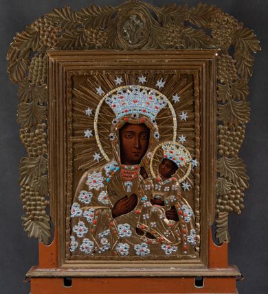 Zdjęcie nr 2: Feretron w typie obrazowym osadzony na niewysokiej, uskokowej podstawie z parą otworów na drążki. Pola obrazowe w kształcie stojących prostokątów ujmuje dekoracyjna rama z rzeźbionym motywem wici winnej latorośli, zwieńczona owalnym medalionem okolonym liśćmi laurowymi z monogramem chrystologicznym na awersie i maryjnym na rewersie. Awers feretronu zajmuje półpostaciowy wizerunek Jezusa w typie Ecce Homo. Jezus zwrócony jest niemal na wprost. Przechyloną, zwróconą nieznacznie w trzech czwartych w prawo głowę charakteryzuje pociągła twarz o delikatnych rysach, długim nosie i krótkim, brązowym zaroście. Długie, falowane włosy opadają na barki. Głowę wieńczy cierniowa korona. Na twarzy, szyi i torsie widoczne są drobne stróżki krwi. Nagą klatkę piersiową Jezusa charakteryzuje rytmiczny układ żeber. Skrzyżowane na wysokości talii, zgięte w łokciach ręce związane są w nadgarstkach sznurem, w prawej dłoni trzyma pojedynczą trzcinę. Na ramiona Jezusa narzucony jest osłaniający biodra płaszcz zdobiony aplikacjami w formie kartuszy z dwoma główkami anielskimi. Niemal całą sylwetkę Jezusa okala promienisty nimb. Elementy takie jak nimb, korona cierniowa, sznur, trzcina i płaszcz są płaskorzeźbione, złocone i srebrzone. 
Rewers feretronu stanowi wizerunek Matki Boskiej Częstochowskiej. Ukazana półpostaciowo, zwrócona frontalnie Maria ma nieznacznie w trzech czwartych w lewo skierowaną głowę. Pociągłą, owalną twarz charakteryzują linearnie opracowane rysy o nieco przymkniętych oczach, długim prostym nosie i niewielkich ustach. Na prawym policzku widoczne dwie, ukośne linie blizn. Maria ubrana jest w suknię i osłaniający jej głowę i sylwetkę płaszcz. Prawą, uniesioną na wysokości klatki piersiowej dłonią o wyprostowanych palcach wskazuje na siedzące na jej lewej ręce Dzieciątko zwrócone w trzech czwartych w prawo. Okrągłą twarz Jezusa charakteryzują rysy dorosłego człowieka, o podobnym do Marii typie fizjonomii. Ubrany jest w długą suknię o trójkątnym dekolcie. Prawą rękę unosi w geście błogosławieństwa, lewą ujmuje trzymaną na kolanach zamkniętą księgę. Karnacje postaci są ciemne, a ich głowy wieńczą korony w typie otwartym, okalają aureole, promieniste nimby oraz wieniec 12 gwiazd. Szaty, korony, nimby, gwiazdy i księga są płaskorzeźbione, złocone i srebrzone. Aplikacje na powierzchni ubiorów oraz dekoracja koron i aureoli naśladuje efekt kameryzacji perłami, koralami, turkusami i bursztynem.         
