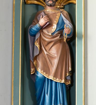 Zdjęcie nr 5: Nastawa ołtarza głównego przyjęła formę przyściennej, trójosiowej, jednokondygnacyjnej struktury architektonicznej ze wieńczeniem. Drewniany stipes ołtarzowy uzyskał kształt leżącego prostopadłościanu podtrzymującego mensę z portatylem, ustawionego na jednostopniowym podeście. Front stipesu udekorowano trzema płycinami obwiedzionymi profilowanymi listwami z rzeźbionymi ornamentami w polach. Na mensie ustawiono drewniane tabernakulum na rzucie trapezu. W dolnej części artykułują je czworoboczne płyciny z ornamentem geometrycznym, rozdzielone spływami wolutowymi podtrzymującymi profilowany gzyms, a w górnej części rozbudowany tron wystawienia. Prostopadłościenne, pancerne tabernakulum usytuowano na osi zdobiąc jego czworoboczne drzwiczki płyciną z trybowanym przedstawieniem kielicha w otoczeniu winnej latorośli i kłosów zbóż. Tron wystawienia przyjął formę trójarkadowej kapliczki zwieńczonej gzymsem koronującym i spłaszczonym dachem pokrytym złoconą rybią łuską. Arkady wsparto na korynckich, kanelowanych kolumienkach. W przyłuczach arkady środkowej, wypełnionej niszą na monstrancję, ukazano uskrzydlone dwie główki anielskie, a w przyłuczach arkad skrajnych motywy ornamentalne. Pod arkadami w osiach skrajnych umieszczono w niszach klęczących na jedno kolana na postumentach adorujących aniołów. Wsparty na arkadach gzyms koronujący ozdobiono profilowaniem i rytmicznie powtarzającymi się konsolkami. Za stipesem ustawiono strukturę ołtarzowa wspartą na wysokim cokole, artykułowaną czterema wysuniętym do przodu dwustopniowymi postumentami dekorowanymi profilowanym gzymsowaniem oraz prostokątnymi płycinami ujętymi w profilowane obramienia. W górnej strefie w płycinach od frontu wyobrażono uskrzydlone głowy symboli czterech Ewangelistów. Idę od lewej jest to głowa woła, anioła, orła i lwa. Natomiast w dolne strefie w płycinach znalazły się od lewej: skrzyżowane bicze z trzciną, na tle których wyobrażono chustę Weroniki, świecznik siedmioramienny z miedzianym wężem na palu na tle pektorału żydowskiego arcykapłana, tablice Dekalogu na tle skrzyżowanych trąb oraz krzyż skrzyżowany z kolumną biczowania wraz z lancą i gąbką na kiju. Pomiędzy postumentami w osiach skrajnych partii cokołowej usytuowano dwoje drzwi prowadzących do zakrystii, zdobionych czworobocznymi płycinami. Na postumentach ustawiono cztery kanelowane kolumny o kapitelach kompozytowych z impostami podtrzymujących belkowanie wyłamane na ich osi. Pomiędzy kolumnami artykułującymi kondygnację w osi środkowej umieszczono pole obrazowe, a w osiach skrajnych półkoliste nisze z ustawionymi w nich na postumentach figurami ŚŚ. Apostołów Piotra i Pawła. Zarówno nad polem obrazowym, jak i nad niszami oraz pod nimi widoczny jest ornament roślinny. Pole obrazowe na osi retabulum przyjęło kształt stojącego prostokąta z nadwieszonym półkolistym łukiem odcinkowym. Ujmuje je profilowana rama. W polu umieszczono obraz Wniebowzięcia Najświętszej Marii Panny, a na dwóch zasuwach przedstawienie św. Urbana oraz św. Barbary. Na belkowaniu w osiach skrajnych nad kolumnami zewnętrznymi usytuowano dwa przerwane przyczółki z leżącymi na nich parą aniołów trzymających krzyż i kotwicę. Natomiast na osi kolumn wewnętrznych na postumentach siedzą dwa złocone putta. Zwieńczenie ołtarza przyjęło kształt leżącego prostokąta flankowanego przez pilaster i kolumienkę podtrzymujących odcinki wyłamanego belkowania, na którym wsparto półkolisty, profilowany łuk odcinkowy wieńczący całość. Ponad tymi podporami umieszczono złocone, siedzące putta, a na osi łuku wieńczącego w promieniach z obłoczkami gołębicę Ducha Świętego. W polu zwieńczenia usytuowano półkolistą niszę ze stojącą figurą Boga Ojca. Ujmuje ją półkoliste obramienie zdobione stylizowaną ornamentyką roślinno-geometryczną. Strukturę architektoniczną retabulum polichromowano w tonacji jasnopastelowej zieleni, ornamenty, profile architektoniczne zostały wyzłocone, natomiast figury apostołów, Boga Ojca oraz aniołów przy tabernakulum i w zwieńczeniu w osiach skrajnych zostały naturalistycznie polichromowane. 